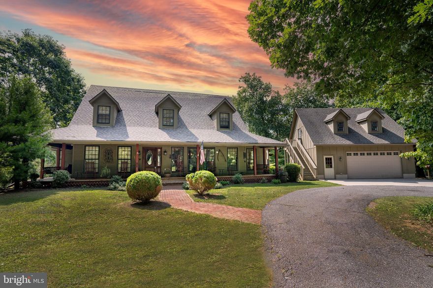 Picture yourself on this front porch with gorgeous views of this property. Where you can rest anytime of the day and soak up the nature that surrounds you. Upon entering this amazing home, you will find a stunning all brick wood burning fireplace with brick hearth and wood accents. Perfect spot to snap a photo and make memories. Look up to see the loft area where you can peek down into the living room. Do not miss the opportunity to take a break in the sunroom and just gaze out into the trees to see what may want to say hello back. The main level primary suite offers a spa like bath with stunning views from your claw foot tub while observing nature out every window and just melt the day away. The kitchen features your oven with brick surround, wood accents, wood beams floating across the ceiling and plenty of storage, a rustic and warm atmosphere. The presence of both a breakfast room and a formal dining room provides versatility for dining options. Main floor laundry. The upper-level hosts two additional bedrooms and a full bath. The abundance of nature will keep you falling in love with this piece of property for years to come. This home captures the essence of cozy and design and is nature-immersed that the property is harmoniously integrated with its natural surroundings, offering a peaceful and inspiring environment. The detached two car garage has an unfinished space above it that could be your workshop or used for additional storage.