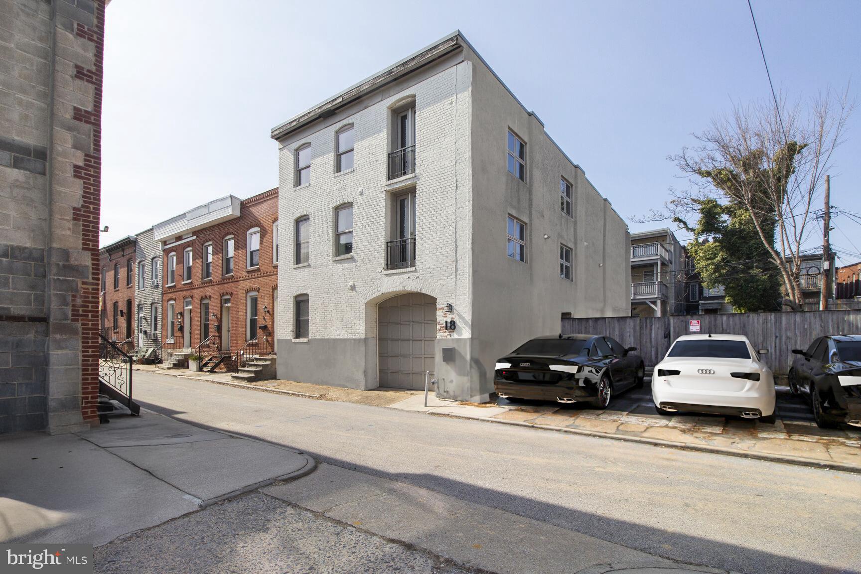 Incredibly rare and unique opportunity to own a stunning end-of-group 1920s carriage house, once a police station, just one block from Patterson Park! Brimming with historical charm, this spacious home showcases original hardwood floors and an expansive footprint—measuring an impressive 28 feet wide by 55 feet deep—making it one of the largest homes on the block. An additional lot (20 N), offering extra parking, a private courtyard, or a prime opportunity to expand the property’s footprint is available for purchase as well. The ground level features a four-car garage, with part of the space currently being converted into an apartment. However, the seller is open to restoring the full four-car garage if preferred. With abundant square footage, historic character, and unparalleled parking, this is a truly exceptional opportunity in one of Baltimore’s most desirable locations!