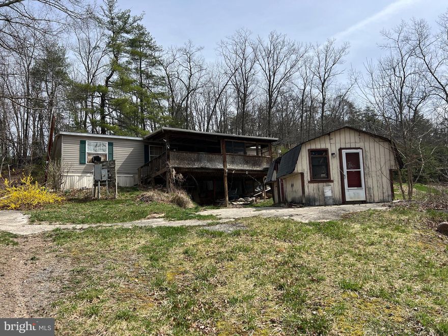 Cheap fixer upper on 2+ acres off South Fork about ten miles south of Moorefield. Joins Little Mountain Hunting Club, so would be great place for member of the Club to place a camper or rehab the manufactured home that is there. Electric and phone available. Seller had used cistern/holding tank for water source. Septic installed, but do not know condition.