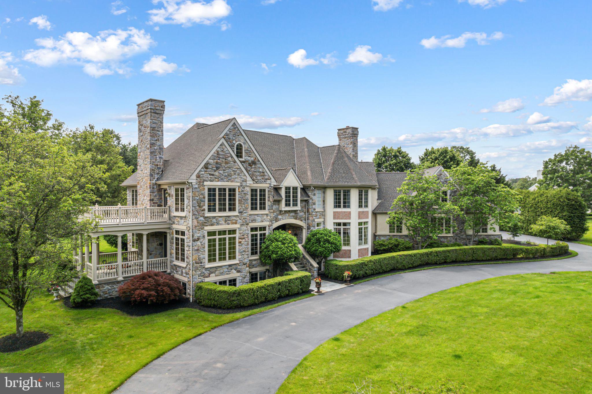 Welcome to your dream home! This exceptional Guidi custom-built estate, a luxurious 6-bedroom, 5.2-bath residence nestled on a stunning double lot spanning over 2 acres in one of Lower Gwynedd’s most coveted neighborhoods, Polo Club Estates. This extraordinary home exemplifies refined elegance, beginning with a professionally landscaped grand entrance, a circular driveway, new roof and a stately paver walkway leading to a covered front entry.
Inside, the marble foyer opens to a sweeping staircase and exquisite imported Murano doors from Italy, guiding you into a dramatic two-story living room. Rich millwork, a custom gas fireplace mantle, and floor-to-ceiling decorative moldings evoke timeless sophistication. Lower terrace with large columns and flagstone pavers off living room. Upstairs, a magnificent library adorned with custom built-ins and ambient lighting offers access to a private upper-level terrace.
A striking 125-gallon see-through freshwater aquarium stylishly separates the sunken family room—featuring recessed lighting, a wood-burning fireplace, and sliding doors to a screened-in slate porch. The gourmet kitchen is a chef’s dream, complete with tile floors, granite countertops, custom cabinetry, a spacious center island, dual dishwashers and ovens, a six-burner cooktop, and a built-in custom refrigerator. The adjoining breakfast room, with its soaring ceiling and expansive windows, offers scenic views of the porch and gardens.
A butler’s pantry connects to the elegant formal dining room, graced with hardwood floors, intricate moldings, a marble gas fireplace, and an abundance of natural light from oversized windows. A recent renovation transformed the private home office, now featuring hardwood floors, recessed lighting, and double French doors. Additional main-level amenities include a full bath, a powder room with a pedestal sink, and a spacious laundry room with a built-in desk, all offering easy access to the attached three-car garage with custom built garage doors.
Upstairs, the expansive primary suite is a true retreat, with cathedral ceilings, generous windows, a cozy fireplace, and a custom walk-in closet. The luxurious en-suite bath includes dual vanities, a large, tiled shower, a Jacuzzi tub, and abundant natural light. Four additional upstairs bedrooms, each with plush carpeting and ample closets, enjoy the privacy of their own en-suite baths. A spacious sixth bedroom on the third-floor features high ceilings and generous storage.
The newly finished lower level is designed for entertaining, boasting high-end resilient flooring, a full bar with pendant lighting, high ceilings, space for a pool table, a cozy lounge area, and a stylish half bath. Behind the barn doors this expansive basement offers the ideal footprint for a custom golf simulator setup. With generous ceiling height, ample floor space, and minimal obstructions, it’s a dream space for golf enthusiasts seeking a private, year-round practice environment.
Outdoors, the expansive EP Henry patio, complete with stone walls and a full outdoor kitchen, sets the stage for unforgettable gatherings. A full basketball court and meticulously landscaped grounds complete this serene and elegant setting.
Come experience the pinnacle of luxury living in the heart of Lower Gwynedd.