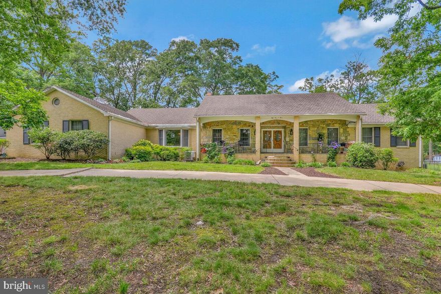 One-of-a-Kind Custom-Built Rancher – 4,787 Sq Ft of Living Space!
Welcome to the home you’ve been waiting for! This stunning, all-brick, custom-built three-level rancher offers 4,787 sq ft of living comfort, thoughtfully designed and lovingly maintained by the original family for over 50 years. Nestled on a sprawling, level lot, this rare gem combines timeless craftsmanship, abundant space, and unbeatable convenience.

From the moment you arrive, the large circular driveway and charming covered front porch set the tone for the impressive interior that awaits. Step through the elegant floor-to-ceiling mirrored foyer into a light-filled living room featuring a bay window, a gorgeous wood-burning fireplace with a handcrafted mantle, and classic crown molding.

Gourmet Kitchen & Entertaining Spaces
The chef's dream kitchen is fully outfitted with a Sub-Zero refrigerator, 6-burner electric cooktop, and double wall ovens. Solid wood Quaker-made cabinetry offers abundant storage, with added touches like a built-in desk, glass display cabinets, and a pantry. A spacious coffee bar area completes the picture. The adjacent formal dining room, with another bright bay window, is perfect for hosting holiday meals or elegant dinners. A powder room, main-level laundry, and extra-large two-car garage with direct kitchen access add convenience and function.

Spacious Bedrooms & Private Solarium Retreat
The main-level primary suite offers a true retreat with multiple closets, a dual-vanity ensuite bath, and direct access to a private solarium—complete with a hot tub for year-round relaxation. Two additional large bedrooms and a dual-vanity full bath offer comfortable accommodations for family or guests.

Upstairs, you'll find two more spacious bedrooms with oversized closets, a large cedar closet, a walk-in attic storage area, and a full bathroom. Two bonus rooms are ideal for use as a home office, den, or art studio.

Ultimate Entertainer’s Lower Level
The expansive lower level is designed for fun, relaxation, and endless possibilities. Two oversized recreation rooms, separated by a custom brick archway, are perfect for entertaining—complete with a full wet bar and antique pool table with ping pong topper included. Host game nights, parties, and more! A dedicated gym/workout room, den/study, and a full bath with walk-in shower offer versatile living. With a private entrance, this level also has strong potential for a separate apartment or in-law suite.

Outdoor Living & Unique Features
Enjoy the outdoors on the spacious deck or brick patio with fire pit—ideal for gatherings or peaceful evenings. Gardeners will love the raised beds with rich organic soil, while a double shed and chicken coop add charm and practicality. Restore the on-site tennis court or transform it into a basketball or pickleball court—the possibilities are endless.

Prime Location
Located within a mile of the Branch Ave Metro station and directly on a major bus line, this home offers quick access to dining, shopping, Joint Base Andrews, Washington Harbor, and Old Town Alexandria.

This one-of-a-kind home offers a rare blend of character, space, and convenience—ready for your family’s next chapter and caring touches. Schedule your private tour today and see all the possibilities this extraordinary property holds!