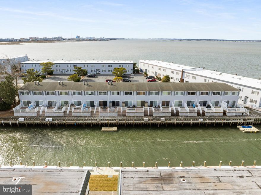 Don't miss this coastal gem in the desirable 94th Street neighborhood. Nestled in a quiet cul-de-sac, this beautifully appointed waterfront townhouse offers the perfect blend of charm, comfort and convenience. Many recent upgrades include vinyl plank flooring and the addition of a half bath in the bedroom suite.  Enjoy direct access to the bay and boat docking along the community bulkhead making it an ideal retreat for water sport enthusiasts.  Outdoor living is a dream with two spacious decks- one on the lower level overlooking the water and another facing south on the second level, perfect for soaking up the sun.  Kayaks, a paddleboard and bicycle are included for your outdoor adventures. Bike barn on site for bike storage. Tastefully decorated with coastal flair, this home is move-in ready for those seeking the waterfront lifestyle. Schedule your showing today-this one won't last long.