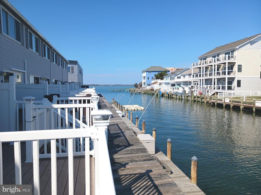 Don't miss this coastal gem in the desirable 94th Street neighborhood. Nestled in a quiet cul-de-sac, this beautifully appointed waterfront townhouse offers the perfect blend of charm, comfort and convenience. Many recent upgrades include vinyl plank flooring and the addition of a half bath in the bedroom suite.  Enjoy direct access to the bay and boat docking along the community bulkhead making it an ideal retreat for water sport enthusiasts.  Outdoor living is a dream with two spacious decks- one on the lower level overlooking the water and another facing south on the second level, perfect for soaking up the sun.  Kayaks, a paddleboard and bicycle are included for your outdoor adventures. Bike barn on site for bike storage. Tastefully decorated with coastal flair, this home is move-in ready for those seeking the waterfront lifestyle. Schedule your showing today-this one won't last long.