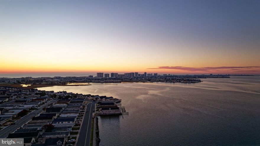 Outstanding Opportunity to own in Montego Bay!  Best street in the community with partial water views and great sunsets!  Features large open floorplan with vaulted ceilings.  An abundance of natural lighting due to lots of windows, picture windows in sunroom and bay window in Dining Room.  Enter through full-width sunroom with two-sided gas fireplace.  Continue into the large living room which is open to the kitchen and dining area.  Fully-equipped Kitchen features center island/breakfast bar, 42" Kraftmaid cabinets, pantry, stainless appliances and laminate floors.  Two bedrooms and hall bathroom, plus large Owner's suite with bedroom, large closet and full bathroom.  There is also a spacious laundry/mudroom with an exit to the side.  Plenty of concrete sidewalks and patio areas and storage shed on left side of home.  Two-car off street parking.  Montego Bay community features community pools, miniature golf course, tennis courts, shuffle board, pickleball, community boardwalk, pier for fishing/crabbing and large pond and walking paths.  Best views for the 4th of July Fireworks show!  Great vacation home or year round residence.  Excellent condition - ready to move in and enjoy!