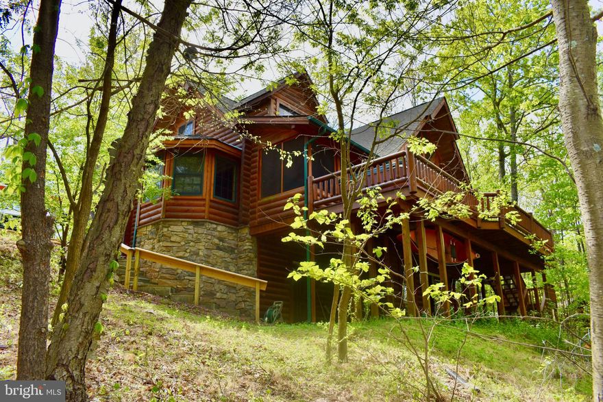 LAKEFRONT Home! Escape to almost heaven in the WV mountains! Beautiful log home, very meticulously cared for by both past owners.  Come make this home your own in this wonderful community and enjoy all the bells and whistles this cabin has to offer.  Lake views throughout multiple areas of the home, screened in porches as well as a private rear deck to get the ultimate lake view that brings you instant peace. New lake trail recently added.  Get those tubes blown up and your paddle boards ready just in time for summer swimming! Cabin comes FULLY FURNISHED so you can move right in, sit down and relax! Would also be a great investment or secondary home as it does generate good income through VRBO currently. Awesome rec room in the basement with pool table, air hockey, and foosball table, all great for entertainment if you love to host. Sleeps 9! Great location and easy to access. You will feel nestled in but close to so much fun, such as, the Woods Resort Golfing and Spa, C&O Canal, Potomac River, Sleepy Creek Forest Reserve with 200 Acre lake and hunting grounds, only about 30 minutes away from Berkeley Springs, and close to shopping. Owner is having the entire log home resealed in May! Schedule your showing and don't miss this opportunity!