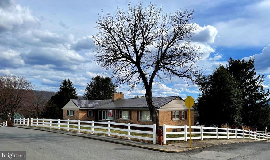 Charming ranch home situated on 3 lots, offering all amenities of small town living.   Welcome Home to this inviting sundrenched home where original craftsmanship meets current updates.  Be greeted by a cozy living area with plenty of windows, natural sunlight and a fireplace. The spacious living, dining & bedroom areas offer gleaming hardwood floors, crown moldings, built ins, wood burning fireplace and access to the upper level deck for catching the awesome views of the town and surrounding mountains.  Perfect place to enjoy your morning coffee! The chef's kitchen is great for entertaining and hosts plenty of cabinet space with granite countertops, pantry and stainless appliances. While preparing your meals enjoy views of the back yard. Three bedrooms are found on the main level, all with hardwood flooring and are spacious in size with plenty of room for your furniture.  2.5 baths including a primary bath on this main floor as well.  Oversized laundry room is right off the kitchen which is spacious enough for the extra refrigerator & freezer.  Located in the lower level are three family/recreation/game rooms which are perfect for all the inside activities.  One of these rooms has a wood burning fireplace with a wood stove insert.  Stay warm and cozy on the cold, blustery winter days.   Plenty of room for a pool table and there is already a shuffle board embedded in the tile floor in another room!   Also located in the lower level is the updated full bathroom, a guest bedroom and an abundance of storage areas. This level opens to the covered patio, BBQ pit and is a great spot to begin and end your day while enjoying your favorite beverage. Let’s not forget about the two car garage.  This home flourishes with unique/fun character.  Well maintained, clean and MOVE IN READY.   Convenient access to schools, hospital, banking & shopping.  Be sure to check out the 3D virtual tour and call today to check this property out for yourself.