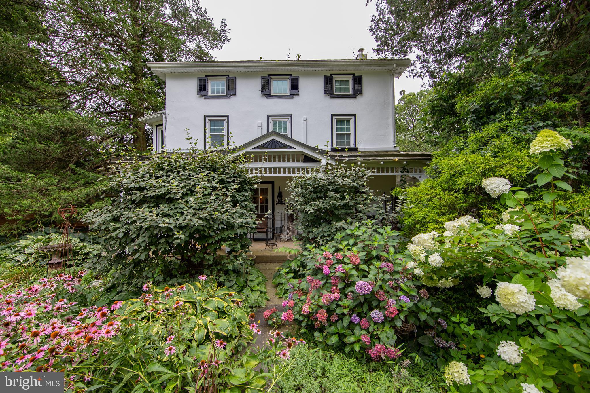 Historic 1830s Victorian Colonial on 2 Acres – Where Timeless Charm Meets Thoughtful Updates.
Step back in time with this enchanting 1830s Victorian Colonial, nestled on a picturesque 2-acre lot. This stucco-over-stone beauty is brimming with original character—from the inviting wrap-around front-to-side covered porch to the deep-set windows and exposed beams that echo a rich historical past.
Thoughtfully updated to meet modern comforts, this home blends old-world charm with 21st-century convenience. Inside, you'll find original woodwork, wide-plank floors, and warm architectural details that create a sense of timeless elegance. A cozy patio off the kitchen invites you to enjoy peaceful mornings or intimate gatherings, while the fully fenced and restored pool area is perfect for summer relaxation.
Upgrades include a Newer Septic System, Water Treatment Conditioner, Generator with a designated electrical conduit, Newer Garage Doors, a Newer Furnace complemented by Five Mini-Split Systems, Newer Propane insert for Brick Fireplace and a replastered concrete pool deck. A newer propane tank adds to the home’s efficiency and functionality. The detached oversized 2-car garage offers abundant space for hobbies, gatherings, or storage—perfect for those who appreciate outdoor living.
This rare offering is more than a home—it's a piece of history lovingly preserved and ready for its next chapter.