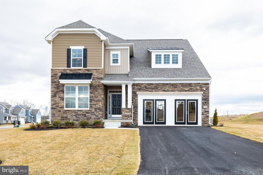 The WAIT is over!!! The Regent II, one of the most beautifully decorated builder's model and spacious floorplans is now available for purchase at Prinland Heights. Located on a prominent corner homesite this home offers a 40 ft. driveway, easily holding 4 cars. Homesite is fully sodded and enhanced model landscaping is offered for the front of home. The exterior of this home is exquisitely detailed with a covered porch area with a striking bold porch pillar, transoms around door, partial stacked stone, large 6 ft. high windows on main level, turned roof gables and oversized turn gable dormer accented with corbels and board and batten siding. Step inside the wide foyer and take in the incredible spacious feel of this home accentuated by the 9 ft. high ceilings on the main level. The foyer features wood beams that lead you past the dining room to the kitchen. The entire main floor is upgraded waterproof luxury vinyl plank flooring. A sitting room on your left can flex for an office, den or library and features 2 6 ft. tall insulated windows. This room features additional ship lap trim. Moving into the dining room a tray ceiling with contrasting paint detail and additional ceiling lighting is accented by an impressive wagon wheel style chandelier with abundant lights to showcase your holiday spread. The dining room offers a box bay window and also features 2 6 ft. high windows letting natural light flood in. Past the dining room is family room that showcases a beautiful gas fireplace with a remote control. This room offers additional lighting and a ceiling fan. You will love the natural light from the 5 windows. The family room features beautiful wood beams compliment the wood tones of the luxury vinyl Plank flooring. The kitchen and breakfast area have a designer inspired white wood slat ceiling and features plenty of lighting. The chef in your family will love the gas cooktop, wall oven and microwave and the stainless vented hood. White 42 in. tall mission style soft close cabinets are beautifully coordinated with Pearl Jasmine quartz countertops and a textured 3 x 12 subway tile backsplash. The white enamel farm style sink features a commercial style kitchen faucet with magnetic docking. The 6 ft long prep island features dark gray stained mission style cabinets on both sides of the island. Looking for a that large pantry, this walk in pantry is larger some walk in closets! The garage is over 21.5 ft. deep and over 20 ft. wide with 10 ft. ceilings. Climb the switch-back hardwood stairs to the bedroom level and see the same warm wood tone Luxury Vinyl Plank flooring in the hallway and primary bedroom. The secondary bedrooms are carpeted and each offers 2 5 ft. high windows, a spacious closet, designer paint palate and ceiling light. Bedroom 2 is 17.5 ft. wide and can easily fit two beds. This bedroom and bedroom three have walk in closets. Bedroom 4 offers the perfect guest suite offering room for a queen sized bed. Hall bath offers ceramic tile flooring, a convenient linen closet, and vertical ceramic wall tile. Longing for a lovely laundry room - look no further, home includes a washer & dryer and is designed to almost make you enjoy doing laundry! The primary bedroom is a show stopper, Luxury vinyl plank flooring, tray ceiling with wood plank ceiling and wooden beams, and a hallway to the massive walk in closet and bath suite. Your king size bed and large furniture will easily fit in this nearly 280 sq. ft. bedroom. The primary bath suite is impressive with a dual shower ceramic tile Roman Shower, dual sink quartz vanity, linen closet and private toilet. The 12 x 24 ft. floor and wall tile give a luxury spa feeling to this bath suite. As if all of this is not enough, the lower level recreation room is fully finished. BOTH available basement areas are finished with a full bathroom and include specialty trim and lighting. An areaway offers easy access to the backyard. Appointments recommended.