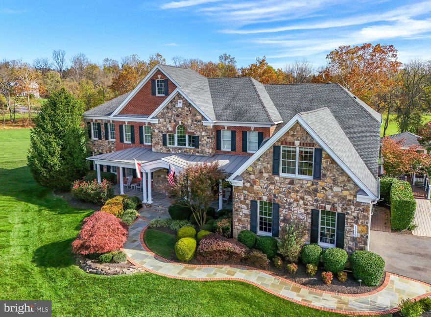 LUXURIOUS 7-ACRE ESTATE HOME IN SHENSTONE RESERVE MINUTES TO DOWNTOWN LEESBURG! Absolutely breathtaking and unmistakably refined, this extraordinary home in the sought-after neighborhood of Shenstone Reserve offers the caliber of home, lifestyle, and location that you have been looking for. Perfectly sited on 7+ lush acres with a sweeping green lawn, a serene creek, and a picturesque tree line, all just moments from town! 

This distinguished “Hampton” model showcases timeless elegance with over 8,900 square feet of beautifully finished living space, offering 10' ceilings on the main floor, upgraded flooring and custom finishes throughout. From the moment you arrive, the curb appeal is unforgettable! Three sides of brick and stone façade, a full covered front porch, flagstone walkway, eye-catching landscaping, and stately stone monuments create a grand first impression.

Step through the upgraded custom front door into a dramatic foyer highlighted by dual curved staircases with wrought iron balusters...a true architectural statement. Entertain in the elegant dining room adorned with crown molding, or gather in the formal living room for intimate moments. A light-filled conservatory offers panoramic backyard views, perfect for reading, music, or quiet reflection, while the main-level office provides a private and productive work-from-home space.

At the heart of the home, the family room is warm and inviting, anchored by a stunning limestone gas fireplace with convenient rear staircase access. The grand Palladian kitchen is designed for both everyday living and elevated entertaining. Featuring high-end custom cabinetry, upgraded countertops, commercial-grade appliances including a 48” JennAir gas range, an oversized entertainer’s island, and a spacious breakfast room, this kitchen is truly a masterpiece! A main-level bedroom with a full bath offers ideal flexibility for multi-generational living or guests. The side-load two-car garage connects conveniently through the mudroom and laundry area.

Upstairs, retreat to the magnificent owner’s suite...a true sanctuary complete with coffered ceilings, a private sitting room, a spa-inspired bath with dual vanities, walk-in shower and soaking tub, and an expanded custom walk-in closet. The home features four additional bedrooms, two offering a private bath and two rooms sharing a full bath. To complete the upper level, an expansive bonus room offers endless possibilities as a study or playroom. Rest and relax in the fully finished walk-up lower level designed for enjoyment, featuring a large recreation room, a high-end state-of-the-art theater room, a full bath, and abundant storage. 

This distinctive home offers a truly magical outdoor setting. Enjoy every season on the oversized custom composite deck that wraps gracefully from the driveway and features a covered, built-in gazebo along with a fully equipped outdoor kitchen complete with grill and smoker. Take in breathtaking panoramic views of the gently rolling countryside, a serene creek, and wooded privacy beyond..an idyllic backdrop for both grand entertaining and quiet evenings at home.

Located off Dry Mill Road, less than a mile from the heart of historic Leesburg, this ultra-luxurious neighborhood places you moments from charming shops, award-winning restaurants, wineries, farmers markets, parks, and major commuter routes, with convenient access to Washington Dulles International Airport. This is more than a home...it is a rare opportunity to own one of Shenstone Reserve’s finest estates!