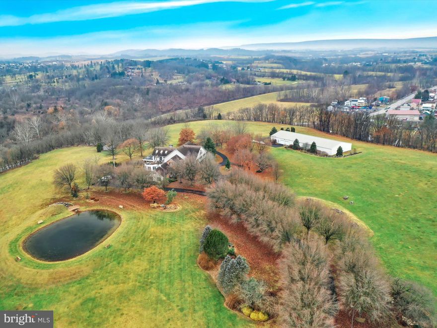 Welcome to 100 Beyerle Road! This one-of-a-kind estate is nestled on almost 24 secluded acres in beautiful Berks County. Once you have entered the electronic/remote controlled entryway gates, you will be greeted by a tree lined driveway leading up to the nearly 10,000 sqft home, which features 5 bedrooms and 5 ½ bathrooms. That’s just the beginning - From the horseshoe driveway, enter the front doors, and you will be greeted by an immense foyer displaying mirroring curved staircases, leading to the second floor. There are four bedrooms upstairs - two of which have access to the front balcony and three of these bedrooms have their own full baths. Back down to the main level, this spacious floor plan is perfectly designed for entertaining. The 1000 sq. ft. family room features a two-story cathedral ceiling, floor to ceiling stone fireplace, massive wood beams, and lots of glass to enjoy the breath-taking views abound. Just a few steps away, and you’ll enter the fully equipped wet bar and indoor sunken hot tub. The family room extends open to a gorgeous, covered, stone patio and wooden deck for the summer picnics. The gourmet kitchen was thoughtfully designed to include duplicate appliances, ideal for large meals. The main living space continues with a formal dining room, formal living room, and a study – take note of the abundant natural light throughout as well as custom cabinetry and ample closets all around. Working from home is no problem with two separate offices, both with built-ins and one of which contains a wet bar and a stone fireplace. The owner’s suite can also be found on the main floor - Featuring another 1,000 sqft, in total and consists of a spacious bedroom with additional sitting room, a dazzling walk-through closet with built-in laundry, a breathtaking full bathroom equipped with all of the extras including a Jacuzzi tub, custom tiled shower, double sinks, built in vanity, bidet and more - literally the owner’s suite from your dreams!This home features an oversized attached 3 car garage, multiple heating / central air systems, sprinklers throughout, a backup diesel generator, a whole house and shop security system, a full unfinished basement with drive down access, and a private well and septic. Enjoy Peaceful Tranquility at the Custom Pond with Sensational Stone Waterfall. Finally, To Round Out this Unique Property, there is a 150’ X 60’ Steel Garage/Shop. This building features a Heated Floor, a Car Wash Bay, a Living Room/Hobby Room, an Office, a Partial Bathroom, Upper Loft Storage, and Plenty of Electricity Throughout. With SO much to offer, this property must simply be viewed in person! Call Today to Schedule Your Own Private Tour!