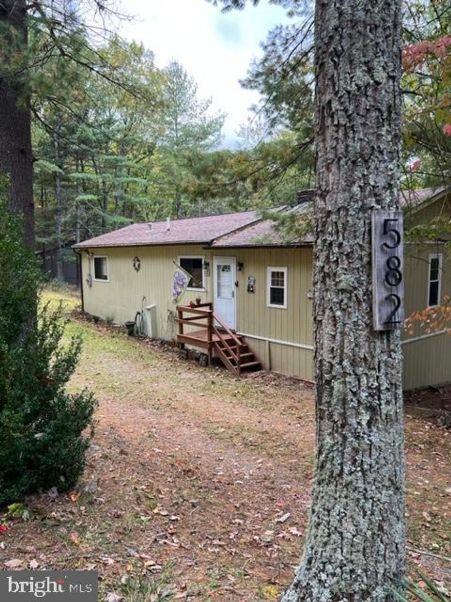 Spacious bungalow on two wooded acres near Lost River State Park could be a great weekend or full time home.   Main floor has 3 Bedrooms, 2 Baths and a large family room area.  Downstairs is a bonus room that could be a  office, game room, whatever you like.   Hang out on the deck and watch the wildlife or relax in the hot tub.