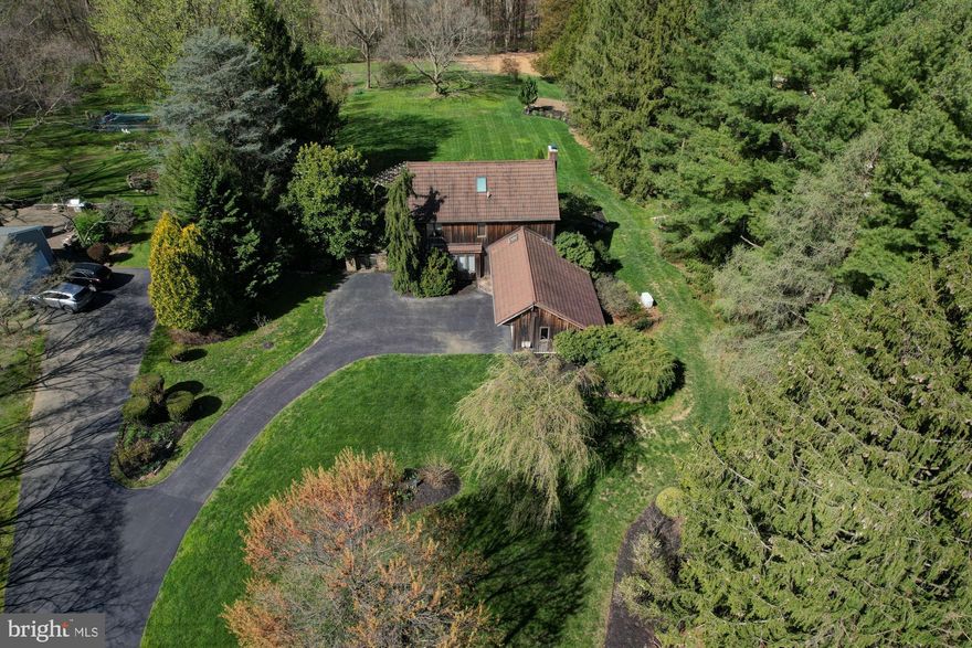 Not your average house! This beautiful contemporary home has it all. From parklike grounds complete with extensive pavers under and around a pergola to a man made fish pond featuring a waterfall. Many special trees including rarer pines, Banana Tree, multiple gardens, vegetable and flower. Just perfect.. Whole house generator included! The entry door is a carved and stately and has etched glass sidelights. The foyer is tile which extends back to the kitchen. The very large kitchen is full of delights like a wood burning fireplace with a new liner done in 2022. A cooks dream with a Jenn-Air as well as Thermador cooktops and a Gaggenau wall oven. This oven is regular and convection. A Dacor microwave which is also convection. With a double window overlooking a serene and private yard as well as a sky light the kitchen is filled with sunlight. The kitchen flows nicely to the dining area with French door access to the covered porch which is wide and long. Don't miss the garden gate with stone pillars on the side of the house. The Family room adjoins the dining area and also has a skylight. The Formal Living room is large and features a custom beautiful wood built in. Plenty of natural light with the double window. Hardwoods are almost throughout this floor. There is a nice powder room and conveniently located laundry room on this floor. Attached two car garage. Upstairs you will find a very large Main Bedroom suite complete with a walk in closet and private bath. The hardwoods are in pristine shape.  There are three additional bedrooms, all having hardwood floors and plenty of windows that share a hall bath that is wonderfully updated . This bathroom also has a skylight. The basement clean and dry with a man door to the outside. Also, accessed from outside, is another garage for the equipment included in sale for the yard! This home is a gem and has been thoughtfully updated over the years and lovingly maintained. Whole House Fan.