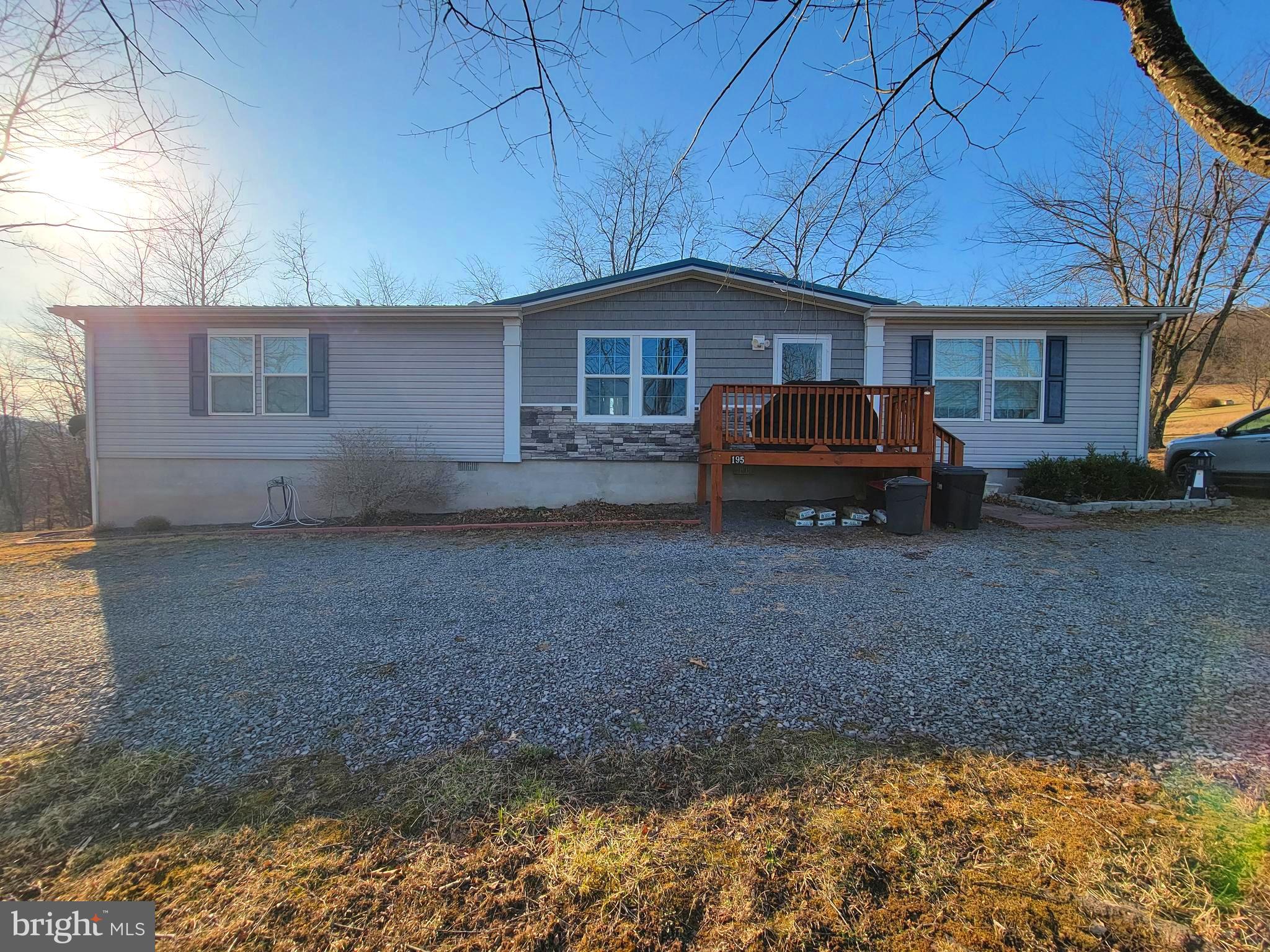 Call today to see this lovely ranch style home located on 2.5 rolling acres with gorgeous mountain views. The home is in very good condition with a metal roof, open floor plan and crown molding throughout. The living room has a feature wall inset and the window faces that amazing view of the mountain ridges. The home feels bright and airy with all the natural light flowing through the large windows. The kitchen has plenty of cabinets and there is an island that provides extra prep space. In the dining area there is an eye-catching barn door that leads to a walk-in pantry with shelves. The layout of the home has the primary bedroom at one end with the other 2 bedrooms at the opposite end. There are 2 full bathrooms, the hall bath and the primary bath. Each bedroom is spacious with large walk-in closets. The primary bathroom has a large walk-in shower with a rain shower head/handheld combo, a double vanity and a separate makeup vanity area. The laundry room has a utility sink and it leads to the fenced-in back yard. This new fenced section provides a convenient area to let fur babies play or a nice space to entertain. The lot is mostly level and has a convenient horseshoe driveway. The home is conveniently located to downtown Romney and Hampshire Square. You are also a 5 minutes drive from the South Branch of the Potomac River and about 45 minutes from Winchester, VA.