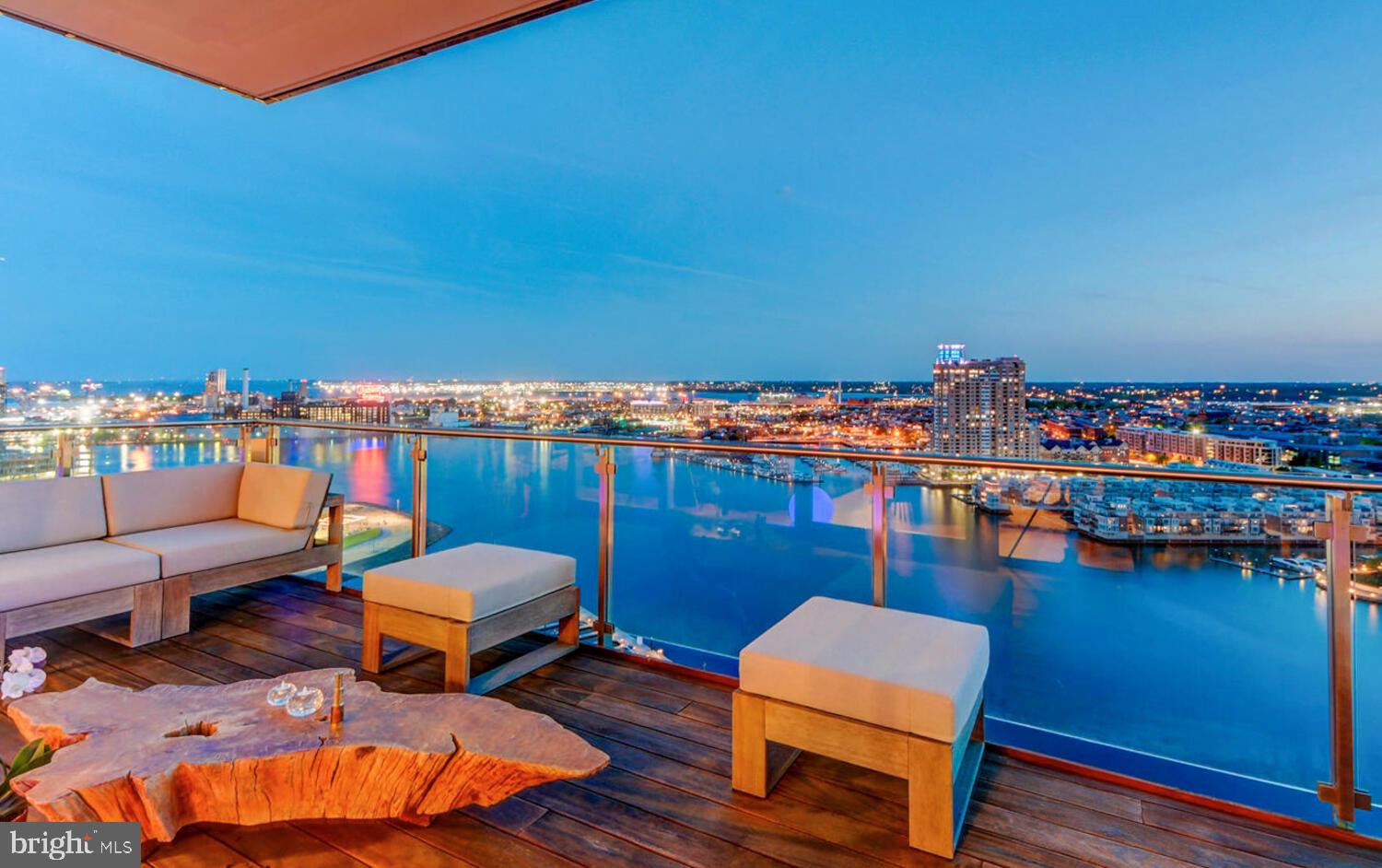 Welcome to the Four Seasons Private Residences in the heart of Harbor East, where luxury, location, and lifestyle converge. From the 23rd floor, this gorgeous 2-bedroom, 2.5-bathroom residence offers spectacular views of the Inner Harbor and marina and the Baltimore city skyline through floor-to-ceiling windows. This refined residence features rich walnut herringbone flooring, a gas fireplace, and high-end finishes throughout. The gourmet kitchen is outfitted with elegant cabinetry, a gas cooktop, wall oven, huge island with breakfast bar, and elegant quartz countertops. The adjacent dining area and wet bar with sink and wine fridge are ideal for entertaining or for a quiet night at home. The primary suite includes a custom walk-in closet and a luxurious marble bathroom with double sinks, a large soaking tub, and separate shower. A second bedroom, also nicely sized, offers comfort and privacy for guests or family.
Enjoy your morning coffee or evening wine on the private balcony, and enjoy the shimmering waterfront and Baltimore skyline. As a resident, you’ll have exclusive access to the private 28th-floor amenity level featuring an indoor saltwater infinity pool, sauna, outdoor deck, fitness center, meeting rooms, and lounging areas — plus a dog-walking area for your furry family members. You’ll also enjoy full access to all hotel amenities, including the outdoor pool and valet services. This property comes with one dedicated parking space in the garage with easy resident access. The Four Seasons features four on-site restaurants, and many amazing dining options just a short walk away in Harbor East and Fells Point. Shopping, parks, harbor activities, museums, and miles scenic waterfront walkways are all close enough to enjoy every day. Experience luxury living at the Four Seasons, it’s more than a residence, it’s a lifestyle.