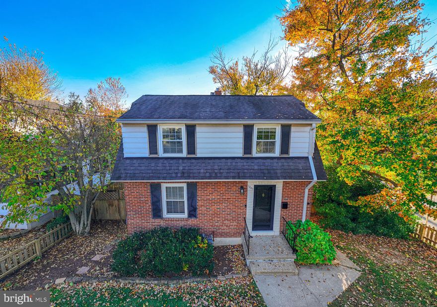 Nestled on a leafy, fenced lot, this charming brick-and-siding Dutch Colonial pairs classic curb appeal with bright, move-in-ready interiors. Sun-splashed living and dining spaces showcase warm hardwood floors, fresh neutral paint, and picture windows, while the updated kitchen features granite counters, a breakfast bar pass-through, pendant lighting, and stainless appliances—perfect for easy entertaining. Upstairs, restful bedrooms enjoy peaceful treetop views, and the crisp full bath offers a clean tub/shower surround. A welcoming front walk and stoop, mature landscaping, and a private side gate enhance everyday convenience, and the home’s timeless façade—black shutters, gambrel roofline, and brick front—delivers standout street presence. A delightful blend of character and comfort in a serene, walkable setting.