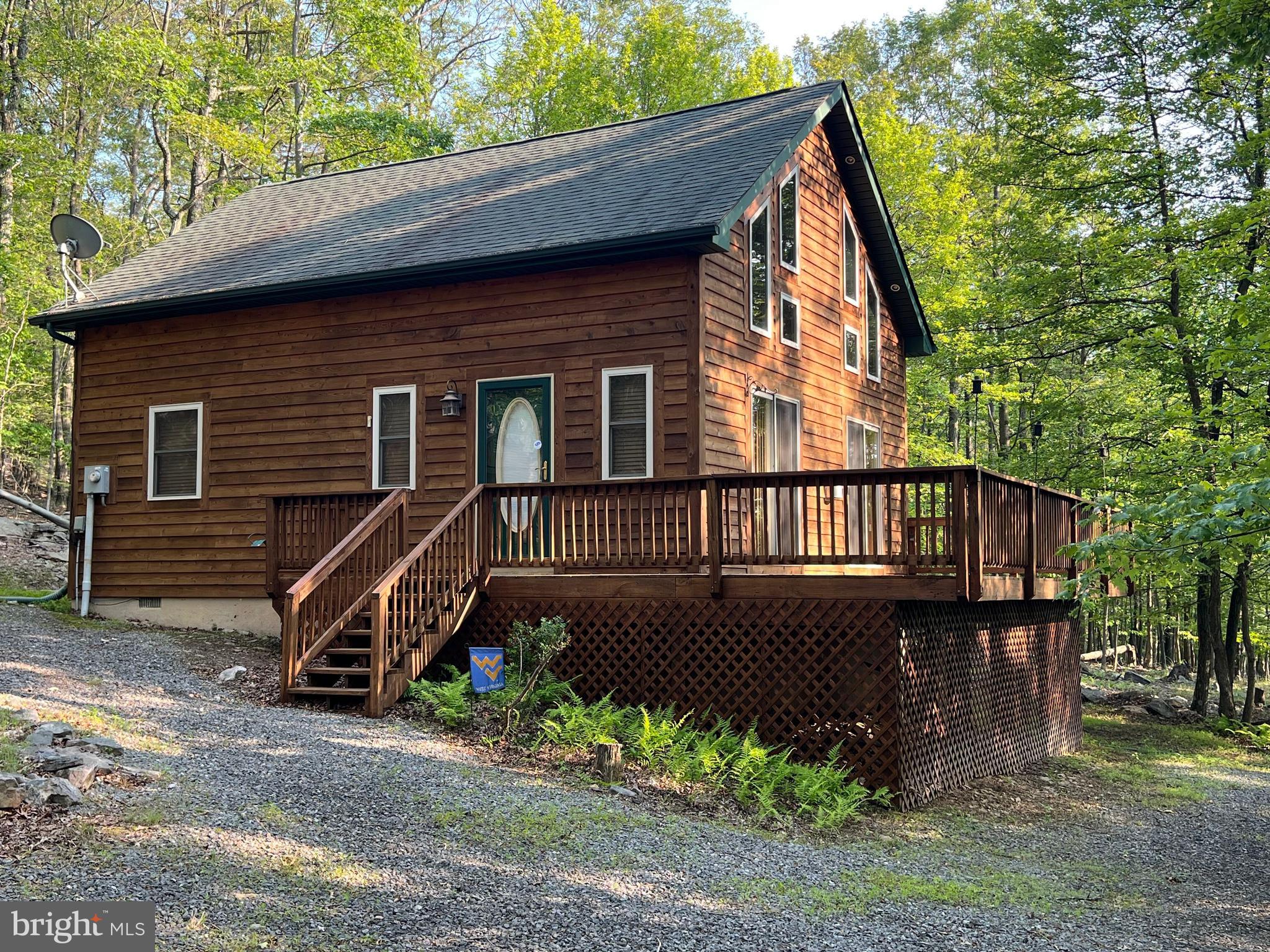 This beautiful cabin sits on just over 11+/- acres and checks numerous boxes for a lot of people. This property offers the perfect blend of rustic charm and modern convenience. When you enter the front door the open floor plan greets you with tall ceilings and beautiful wood accents. Nestled inside of a gated community this home offers a large front porch, entry level bedrooms, a radon mitigation system, privacy and the list goes on and on. This home features 2 bedrooms and 2 bathrooms but the current owners are using the upstairs loft as an additional sleeping area. This space could also be used as an office or several other options as well due to its versatility. A beautiful walk out deck awaits you as the day draws to an end and you want to relax on your porch as the sun sets or during the mornings as you enjoy your coffee. If you're seeking a permanent retreat or a weekend getaway, this rustic cabin offers the perfect blend of comfort, convenience and privacy. Around 2 1/2 hours from Washington DC and around 30 minutes to Berkeley Springs, WV this getaway offers the peace and quiet you are looking for with easy access to anything you need. Give me a shout today to schedule your private tour.