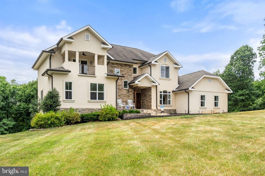 Luxury custom-built Mediterranean inspired home nestled along the scenic Snickersville Turnpike in the Hearth of Virginia’s Wine and Hunt Country.  This charming property spans 7.59 acres of rolling farmland offering privacy and charming views in Loudoun County, perfectly situated between Purcellville and Middleburg. No detail was left undone, the home feels like a high-end model home, and is crafted from insulated concrete which adds to the private feel and is energy efficient. On the main level, you will find an open gourmet kitchen with high-end stainless steel appliances and breakfast nook. The kitchen has ample storage and counter space, and is open to the light-filled living room completed by a gas fireplace. The main level also features the primary suite with an oversized full bath and walk-in closet; a spacious dining room; an office; a half bathroom room; a mudroom with custom storage; a laundry room; direct access to the oversized 3-car garage; and walkout access to the private backyard and garden. Upstairs you will find 3 bedrooms, each with its own access to a full bathroom and a large recreational room. The walkout basement features French doors and a beautiful wet bar with a kitchenette that is perfect for entertaining. There is a large, open living space, the 5th bedroom, and a final full bath which also has access via the living space, and tons of storage space. Outside, there are 2 spacious patios where you can enjoy the quiet nature, surrounding trees, views and gardens featuring two pear trees along with Blueberry and Raspberry bushes. The location provides easy access to the Virginia Piedmont and Blue Ridge Mountains while still being within a driving distance of all Northern Virginia has to offer. Close by vineyards, breweries, farms, and the Application Trail add to the rural charm while the proximity to Middleburg and Purcellville gives access to all major amenities while maintaining the private feel of the countryside.