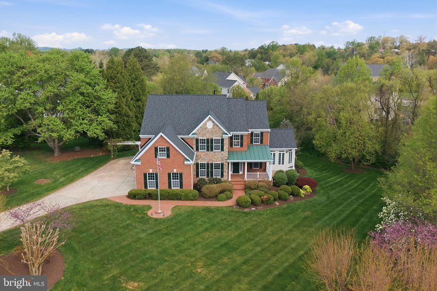 Discover refined living in this exceptional 5-bedroom, 4.5-bath residence, ideally positioned on a private 0.85-acre lot in the prestigious Stuart Estates community. Blending timeless elegance with modern comfort, this light-filled home offers a thoughtfully designed layout ideal for both everyday living and sophisticated entertaining. The main level features formal living and dining rooms, alongside a dramatic two-story family room highlighted by a striking fireplace that anchors the home. The well-appointed kitchen offers abundant cabinetry, generous counter space, and a sunlit breakfast area featuring a Tiffany lamp that creates a warm and inviting start to the day. Just beyond, a wall of windows in the sunroom provides a peaceful retreat with serene views of the lush backyard and beautiful sunsets. A convenient rough-in for a second laundry room on the main level adds valuable flexibility for future customization. Upstairs, the spacious primary suite serves as a true sanctuary, complete with walk-in closets, a spa-inspired bath designed for relaxation, and a private laundry room for added convenience. A secondary bedroom with a private en-suite bath adds comfort and privacy, while additional generously sized bedrooms share a well-maintained hall bath, offering flexibility for guests, work from home needs, or daily living. The finished basement adds approximately 2,100 square feet of versatile living space, complemented by an additional 400 square feet of unfinished storage. The lower level also includes a beautifully remodeled bathroom, making it ideal for recreation, guests, or multi-generational living. Designed for versatility, the home includes multiple living spaces that easily adapt to your lifestyle, whether gathering, working, or unwinding. Outdoor living truly shines with an expansive deck, complete with an electronic retractable awning for effortless shade. Just beyond, a spacious patio overlooks a beautifully landscaped, private backyard that's perfect for enjoying breathtaking sunsets. A professionally installed irrigation system keeps the grounds lush with minimal upkeep, while a recirculating stream cascades over natural stone into a serene pond, creating a peaceful and visually captivating water feature. Recent upgrades include a 2 year old roof, a whole-house generator, and a leaf guard gutter system, offering reliable comfort and peace of mind year-round. Andersen French doors provide seamless walkout access to both the deck and the basement. The three-car side-load garage further adds convenience and curb appeal. Perfectly located near downtown Herndon and Reston Town Center, with easy access to major commuter routes, shopping, dining, Metro, and Washington Dulles International Airport, this home offers a rare combination of estate style space, modern convenience, and a prime Northern Virginia location.