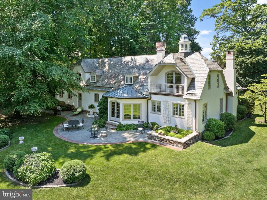 Welcome to 599 Longchamps Drive, a one-of-a-kind architectural masterpiece nestled in the heart of the Main Line, within coveted Radnor Township. Your heart is captured from the moment you see the breathtaking cupola with its custom weather vane, and pitched slate roof, accented by copper gutters—a trio of timeless details that set the tone for the beauty that lies within. Originally the carriage house for the famed D'Orsay estate, this enchanting residence was completely transformed by its current owners in 1995, beginning with a stone foundation and terra cotta block under the stucco. Every inch of this picture-perfect gem has been curated with the finest quality and craftsmanship, all while preserving the timeless charm and soul of its historic roots. Perfectly sited on a stunning 1-acre lot, from the moment you arrive, you’ll feel as though you've been transported to the South of France. Upon opening the front door, an air of sophisticated elegance abounds as gleaming walnut floors welcome you into the two-story Foyer. Featuring a custom walnut staircase, intricate millwork, and detailed crown moldings, the Foyer introduces the elevated design and seamless, natural circular flow that continues throughout the First Floor. The elegant Living Room, anchored by a stunning fireplace flanked by custom display cabinetry, exudes warmth and refinement, while a private Office offers a quiet retreat. The inviting Family Room is a sunlit sanctuary, featuring bay casement windows and elongated elliptical French doors that open to a slate Patio framed by manicured boxwood gardens—creating the perfect balance of beauty, privacy, and indoor-outdoor living. At the heart of the home lies a European-inspired gourmet Kitchen, complete with high-end appliances, marble countertops, and views into the Dining Room, overlooking  a gas fireplace and picturesque ivy-covered brick courtyard. The Dining Area  opens directly to this private courtyard—perfect for seamless entertaining and al fresco dining in a truly enchanting setting. A convenient first-floor Laundry/Mudroom and an attached two-car Garage add to the home’s effortless livability. Ascend the sweeping staircase in the Foyer to find an exquisite Primary Suite, where elegance and serenity converge. The suite features a tray ceiling, its own fireplace, and a unique architectural view into the home’s cupola. French doors lead to a private balcony overlooking the lush, flat backyard. The suite also includes his and her walk-in closets and a luxurious en-suite Bath featuring limestone floors and marble countertops. Three additional Bedrooms—each with unique dormers and charming window seats—share an updated Hall Bath, offering warmth, character, and comfort for family or guests. An unfinished Lower Level provides abundant storage space, with the exciting potential to finish and expand the home’s living area to suit your needs and lifestyle. Outside, the backyard is a private haven, featuring a spectacular Patio framed by mature landscaping—ideal for hosting, relaxing, and making cherished memories. This is more than a home; it is a rare and remarkable lifestyle opportunity. Come experience the magic of 599 Longchamps Drive—where Old World charm meets modern elegance in the sought after D'Orsay neighborhood. SHOWINGS BEGIN THURSDAY APRIL 3rd