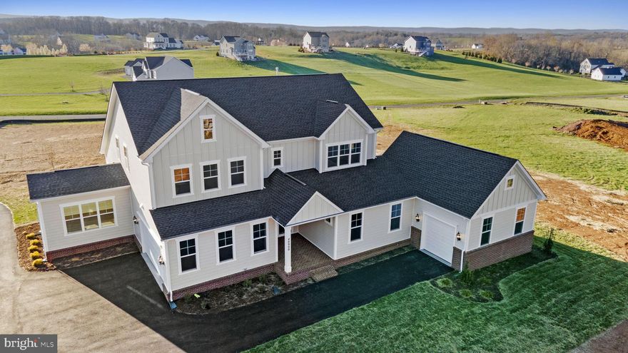 Brand New Multi-Gen Weymouth estate home situated on a corner homesite in a cul-de-sac on over 3 acres with impressive views of the  rolling hills of the Loudoun County countryside is ready for you to call home! 
This multi-generational masterpiece spans three levels, each thoughtfully designed to provide unparalleled comfort and style.
As you enter the main level, you are greeted by an extension that not only expands the living space but also boasts 9 ft ceilings adorned with an exquisite artisan trim package. The heart of this home is the entertainer's dream kitchen, featuring Carrara Morro countertops, crisp white cabinetry, two large islands, and chef’s gourmet kitchen. The kitchen seamlessly opens to the generous grand room, complete with vaulted ceilings, a cozy gas fireplace and dining room. Adjacent to the grand room, a light-filled conservatory beckons, offering scenic views of the picturesque Loudoun countryside.
The main-level primary bedroom, discreetly tucked away at the rear, exudes luxury with two oversized walk-in closets and a deluxe en suite, with a spacious frameless shower, classic pedestal soaking tub and dual vanities. The mudroom, conveniently located off the attached 2-car garage, doubles as a laundry room, adding to the home's practicality. A true highlight is the home within a home on the main level. Our multi-generational home design, offering a bedroom with en-suite bath, living and dining room, a well-appointed kitchenette with stainless steel appliances, granite countertops, and matching white cabinetry.  The private suite also includes it’s own private 1-car garage with flex space. Ideal for extended family or long-term visitors, this space is a testament to the home's versatility.
Ascending to the upper level on the oak staircase, a loft opens up to the main level below, creating an open and airy atmosphere. Three additional secondary bedrooms, two full baths, and a dedicated laundry room complete the upper level. The lower level continues the theme of luxury with an expansive recreation room, a finished bedroom, and a full bath. Unfinished spaces present endless possibilities for customization, whether you envision a media room, exercise space, or additional storage. This estate home also boasts an additional, separate 2-car garage providing additional space for your prized vehicles.
Experience the pinnacle of grandeur, versatility, and comfort in this exceptional residence, where every detail is a testament to the unparalleled craftsmanship and thoughtful design that defines this Weymouth estate. Don't miss one of the last opportunities to live in this spectacular community enveloped in privacy and scenic views of the Shenandoah mountains, while still just minutes away from shopping, dining and everything you need!