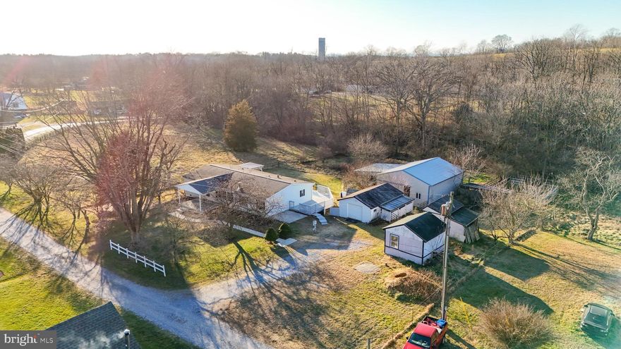 Set on 3.1 peaceful acres just outside of Hagerstown, this charming farmette offers the best of both worlds—quiet country living with shopping, dining, and daily conveniences just 15 minutes away. Whether you’re dreaming of space to spread out, room for animals, or simply a quieter pace of life, this property delivers.

The one-level home features three bedrooms and two updated bathrooms, anchored by an open-concept living area that feels bright, welcoming, and easy to live in. A cozy freestanding fireplace stove adds warmth and character, creating the perfect gathering spot during cooler months.

Recent updates include LVP flooring throughout, freshly painted cabinetry, and a newer HVAC system, giving peace of mind along with modern comfort. The primary bathroom features a fully tiled walk-in shower, while the second bathroom has also been tastefully updated.

Step outside and enjoy expansive outdoor living with a full-length rear deck spanning the back of the home, ideal for relaxing or entertaining, along with a welcoming front porch to take in the surrounding views. The land is well-suited for animals and hobby farming, offering open pasture space, multiple sheds, and outbuildings ready for livestock, storage, or projects.

Clean, well-maintained, and full of potential, this property is perfect for those looking to bring their animals, enjoy wide-open space, and still stay connected to town conveniences.