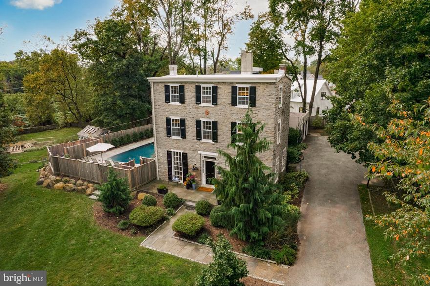 Come see this beautiful Federal farmhouse located on a quiet tree-lined street in the heart of Wyndmoor featuring a stunning Wissahickon schist facade. This unique property combines the allure of its rich history with modern amenities and is filled with character. With 6 bedrooms and 4.5 bathrooms spanning across three stories and 4,422 square feet, this residence offers ample space for comfortable living. As you step inside, you'll be greeted by the old-world charm of the living room which features soaring ceiling heights, a cozy gas fireplace with intricate detail, and timeless hardwood floors. Adjacent you will find the parlor room with great light perfect for a refined study. The kitchen has been updated with stone counters and top-of-the-line Sub Zero and Viking Professional appliances. The spacious dining room comes complete with a second gas fireplace, excellent for entertaining.  A magnificent two-story addition was masterfully crafted by McCoubrey Overhaulser and McEwen Architects, enhancing the home's allure. The family room is located on the lower level of this award-winning addition, which offers a surround of windows, an abundance of natural light, an exposed stone wall, and radiant flooring. You can step outside onto the picturesque flagstone patio with a private saltwater pool, shower, outdoor kitchen, and dining area, as well as an additional stone fireplace. The garden is adorned with lovely mature plantings, adding a touch of natural elegance to the surroundings. The upper level of the addition boasts a spectacular primary suite, featuring a spacious walk-in closet and a luxurious white marble bathroom with a dual shower, separate soaking tub and radiant flooring. Above the primary suite wing, you will find separate quarters with full bath perfect for an office or guests. Set apart from the primary suite you will find four more bedrooms w/ 2 additional full baths located on the 2nd and third levels. Off the family room, you will find a beautiful Glenna Stone-designed mudroom with custom cabinetry, and a well-appointed half bath. The laundry area is located adjacent to the kitchen and connects directly to the oversized two-car attached garage, with a slat panel storage system, that provides convenient parking options for you and your guests. In addition to the electric and plumbing being updated, the home has high-velocity air conditioning and Verizon Fios throughout. Take advantage of the impeccable location which is walkable to all of the restaurants and cafes in Wyndmoor and the village of Chestnut Hill. The natural beauty of this setting is only rivaled by the stunning Wissahickon Valley which is located a short distance from the property. This is a must-see home, where history meets modern comfort in perfect harmony. Schedule a private tour today!