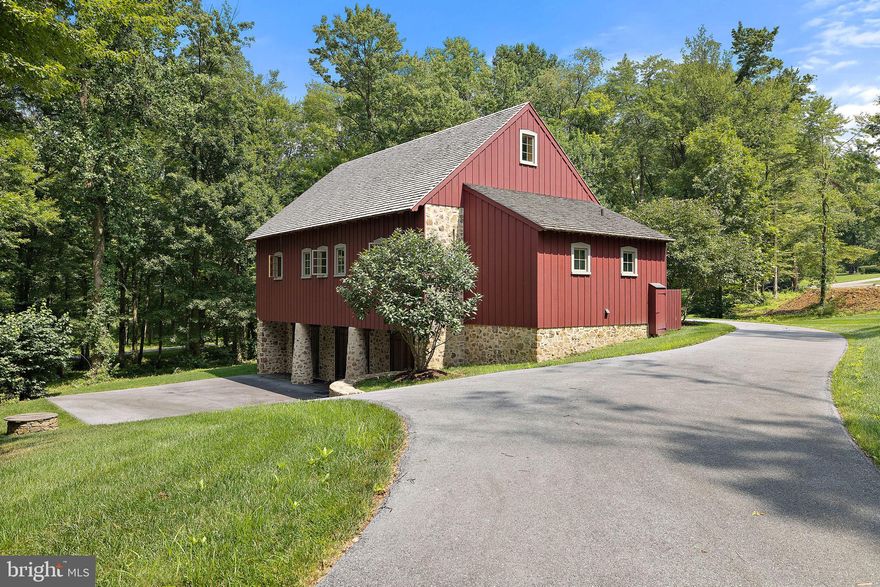Welcome to 82 Brownstone Lane, "The Bank Barn" in Olde Bulltown Village. This remarkable reproduction bank barn is a testament to fine craftsmanship and a true work of art built and designed by Stoltzfus Builders just a decade ago. Originally built as a showpiece space to display a car collection and gather with friends, this property offers many opportunities to the next owner. Transform this home into a one-of-a-kind residence by modifying the floor plan to accommodate additional bedrooms and baths. There is also space on the lot to construct an additional residence in front of this show piece or design and build your dream home on an adjacent lot keeping "The Bank Barn" for antiquities collections and entertaining. As you step inside, you'll be captivated by the architectural beauty and thoughtful design that exudes a sense of history and character. Every element of the space has been carefully replicated to evoke the charm of a bygone era while offering modern amenities and functionality. The upper level  of this "The Bank Barn" has been structurally designed to accommodate several vehicles while still leaving space for entertainment. The large barn doors offer the convenience of easily accessing your collection or allowing for an expansive entertainment area. Adorned with rich pine hardwood, it exudes a sense of rustic charm and sophistication. Long narrow windows on the bank side of the home  emulate the nostalgic look of ventilation windows on an old tobacco barn, while easy-to-open casement windows along the other three sides create an inviting connection to nature. This versatile space offers a large open area complete with a kitchen, full bath, and storage closet. The kitchen details include soft-close drawers, soapstone countertops, stainless steel appliances, and a charming soapstone farmhouse sink. The bathroom features a tile walk in shower with glass door and an antique-style vanity with a granite countertop, adding a touch of classic elegance. The lower level includes three spacious garage bays with wide barn doors, making it ideal for housing vehicles or other prized possessions. A large work table along the front wall provides a functional workspace, while the storage area equipped with shelving, a sink, and washer/dryer further enhances the practicality of this remarkable space. The lower level is conditioned by radiant floor heat.  Looking for additional living space, the lower level could be converted to expand the use as a residence. Don't miss this opportunity to own a truly exceptional property, where your passions and collections can find a place to shine. Embrace the endless potential of this reproduction bank barn and create a space as extraordinary as you are.