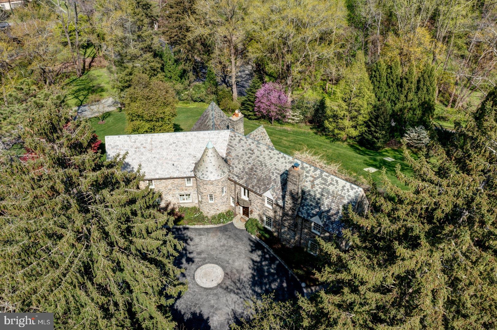 Located on one of the most desirable streets along the Main Line, walking distance to the train and Merion Cricket Club, this stately stone and slate home on Cheswold Lane combines the perfect mix of old and new. As you approach the top of the circular driveway, the custom copper gas lanterns on the main house and pool house welcome you to the beautiful compound. The 2.19 acres has rolling mature landscaping with gorgeous stone retaining walls surrounding the main house and the new pool house. The newly built 3 story pool house has on its main level a wet bar, half bath, washer and dryer and workspace. The wide interior stairway leads you to a full-size bedroom (one of the 5 overall bedrooms) and full bathroom detailed with marble mosaic tiles and heated floor. The basement of the pool house has ample room and ceiling height for the utilities and lots of extra storage. The main house, pergola and peacefully meandering stone walk to the secluded spa, pool and pool house make you feel like you are on vacation. The Lutron outdoor lighting system, irrigation system and integrated wifi between the main house and pool house allow seamless entertaining and use. Inside the main home, is beautiful sunny recently renovated white cabinet kitchen, large 4.5’ by 10’ island with state-of-the-art appliances just off of the stone porte cochere, mudroom and home office. The kitchen opens beautifully into the family room with a fireplace, endless sunlight and access to the blue stone patio and stunning mature pergola. The sunny master bedroom suite with fireplace consists of separate large dressing closets and a luxurious oversized marble bathroom with heated floors, towel warmers, steam shower and gorgeous tub all tastefully designed with tons of sunlight. There are 5 gas burning fireplaces throughout the home including the walkout lower level. The elegant living room with a fireplace has 3 sets of tall French doors which lead to the bluestone terrace under the pergola making for perfect dinner settings, parties and many a memorable gatherings. Connected to the light bright dining room with fireplace is a wet bar including an ice maker and custom wine refrigerator closet with approximately 400 bottle capacity. 3 HVAC zones plus another zone in the pool house, copper gutters and downspouts, walk-out lower level, second floor laundry, all double pane new windows replaced in 2013, irrigation system, invisible fence, 2+ car garage plus a porte corchere….MORE PHOTOS TO COME. Seller, has a PA Real Estate Brokers License