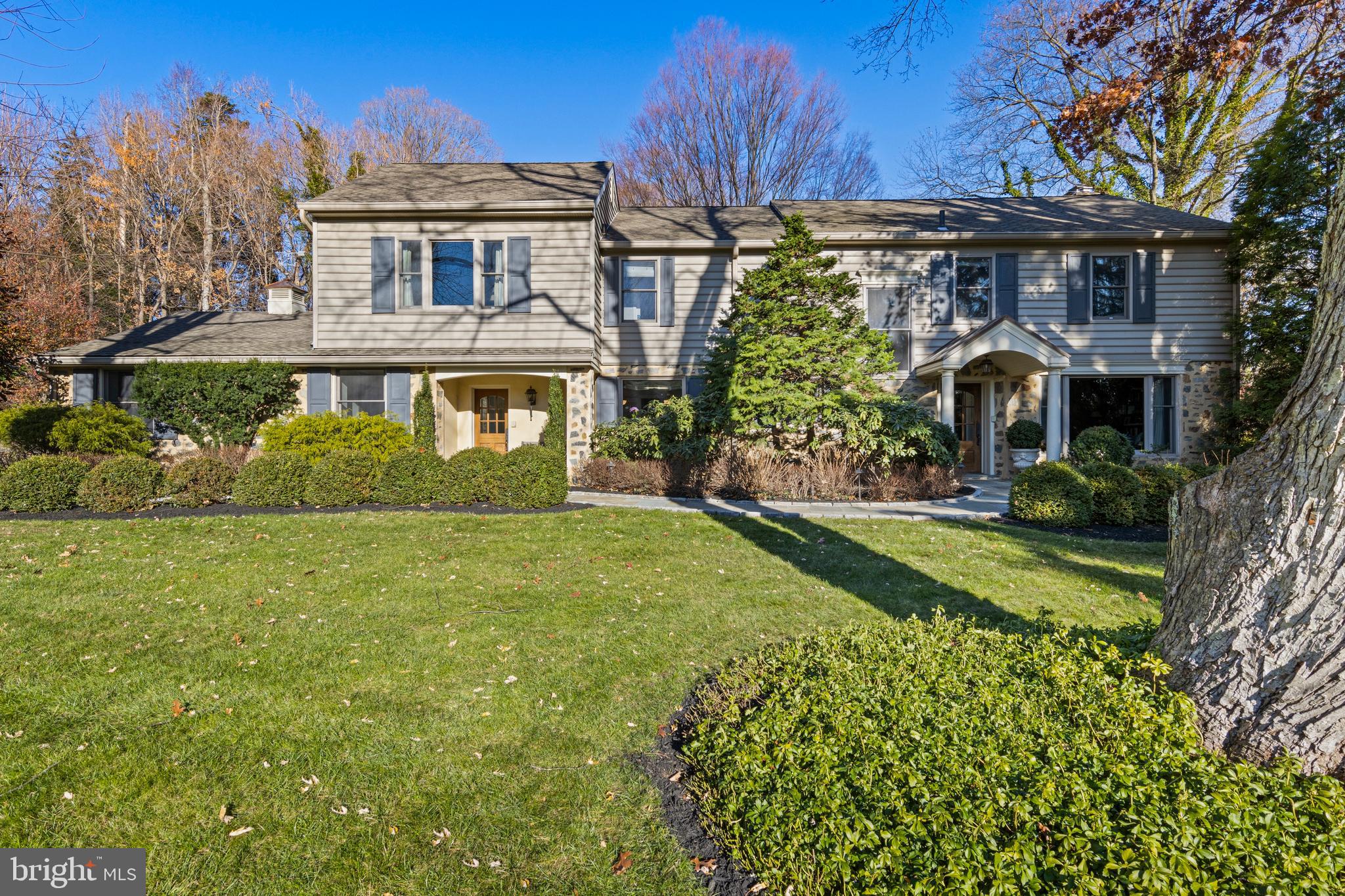 Welcome to 1633 Lark Lane, a meticulously maintained and thoughtfully upgraded 4-bedroom, 3.5-bath Colonial in the award-winning Lower Merion School District. Situated on a private lot that is well over an acre, at the end of a quiet cul-de-sac next to fifty acres of preserved land, in a welcoming neighborhood, this home offers a peaceful, country-like atmosphere, all while being just minutes from the Villanova train station, Amtrak and the vibrant communities of the Main Line. Built in 1957, this spacious home seamlessly blends the character and craftsmanship of a classic home with the clean lines and contemporary updates. Every detail has been carefully maintained and enhanced using the highest quality materials, with expert guidance from professional landscapers, hardscapers and designers.
A classic mix of stone and light gray siding, complemented by dark gray shutters and meticulously designed landscaping, elevates the home's curb appeal. A Belgium block driveway, lined with three stately stone columns topped with lanterns, makes for a grand entrance. Cobblestone pavers, a retaining wall, and a new portico with copper roof elevate the exterior. Dozens of acres of deed-restricted open space sit to the left, creating a peaceful oasis and ensuring privacy. Custom oversized front doors with Rocky Mountain hardware set the tone for both the formal entrance door and the mudroom door for everyday convenience.
Step into the inviting foyer, where a new banister and railings enhance the home’s timeless charm. The renovated kitchen combines modern elegance with functionality. White quartz countertops and a quartz slab backsplash complement the inset white cabinetry with glass door accents. A center island with prep sink and island seating is ideal for casual dining, while high-end appliances, including a Sub-Zero refrigerator, Theramador professional range, and Miele dishwasher, elevate the cooking experience. A built-in banquette with white leather upholstery and a modern chandelier create a welcoming dining space. Adjacent to the breakfast area, custom-built arched bookshelves frame the wood-paneled pantry doors. A desk area is also found here. The formal rooms on the main level offer elegance and versatility. The dining room features custom marble built-ins for showcasing fine dishware, and French doors allow natural light to flood the space. The family room and library provide panoramic views of the expansive backyard, blending indoor and outdoor living. New ceiling fixtures and sconces in the dining room add a refined touch. A powder room, also with new fixtures, and a mudroom with access to the attached two-car garage complete this level.
Upstairs, the primary suite offers a luxurious retreat, complete with a spacious walk-in closet and a stunning sitting room/office with a wall of windows and very high ceilings. The primary bath has been updated with new faucets and lighting fixtures for added elegance. Three generous additional bedrooms each include built-in closets. The brand-new lower level (2025) adds versatility, featuring a bonus room with LVP floors, a dedicated exercise room with tile flooring, and a full bath. Recent upgrades include a French drain, sump pump, new windows and a Generac whole-house generator for peace of mind. A true highlight of the home is the spacious, private backyard. The design of the home ensures a seamless connection to the outdoors, with large windows offering panoramic views from the kitchen, family room, library, and sitting room. Step outside onto the expanded patio, where a built-in Viking gas grill and lush landscaping create a private oasis. The flat driveway doubles as a pickleball court, and the spacious yard offers ample room for outdoor activities. Located in a welcoming, walkable neighborhood, this one-of-a-kind Colonial offers a rare opportunity to own a thoughtfully updated, move-in-ready home in a prime Main Line location.