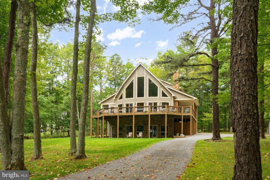 Virtually lakefront, 5BR, 5BA  3300sf custom-built chalet in desirable Turkey Neck area of Deep Creek Lake! Enjoy year-round water views from this front row home - the only thing between you and the lake is a narrow community walking path down to your dockslip. Open floor plan with vaulted ceilings, oak hardwood floors, maple Kraftmaid cabinets, granite, high end finishes & appliances, as well as 2 stacked stone gas fireplaces. Hot tub hookup, 200 amp electrical service, wraparound deck and a gorgeous yard with mature trees.  Flat, easy access to the dock slip, community tennis courts, parking area & lakeside walking trails at Cedarbrook. Partially furnished.