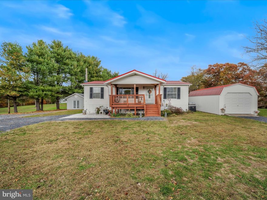 This doublewide mobile home has 3BR/2BA, living room, kitchen, laundry room and is situated on 1.83 acres with very light restrictions (no junk or unlicensed vehicles)...beautiful country setting.  Relax on the front porch or the back deck! Also included is a 14' x 32' detached workshop that has electric and heat. Great area for the handyman or craft person. Storage is a key point with the 2 sheds and a run-in building that also convey.  The home is fully skirted, has 32 footers and is strapped down, so financing may be limited.  The house sets back off the road so no worries about traffic noise.