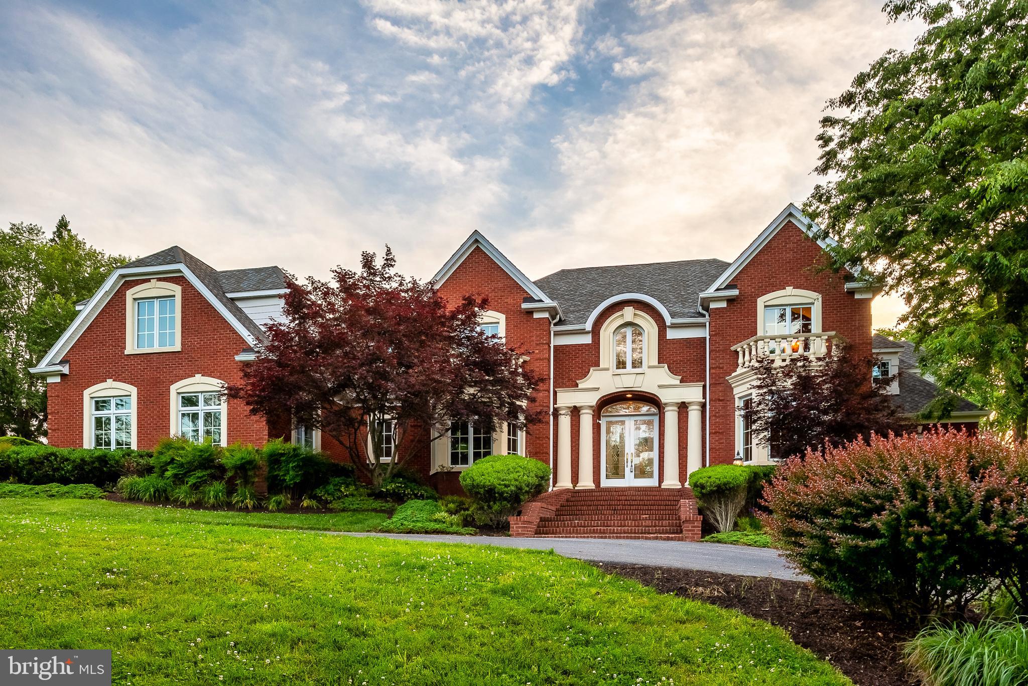 Classic all brick estate home majestically sited on over 3 acres in one of Howard County's most prestigious and finest neighborhoods, The Chase. A circular driveway leads you to the private setting and grand columned entrance with elegant French Doors. The foyer is a bright and open two-story entrance. French glass doors lead to a first-floor library with beautiful mahogany-stained bookshelves, a bay window and can be accessed by the main level primary bedroom as well. The primary suite features built-ins, a fireplace, and access to the patio. You will find a gorgeous primary bath with a whirlpool tub, huge shower, dressing area, and two walk-in closets. The two-story living room with fireplace features a wall of windows and glass French doors leading to the patio and is perfect for formal entertaining. The formal dining room has a wonderful bay window and is flanked by a wet butler's pantry. The kitchen is a cook's dream with custom cabinetry, a separate pantry, a built-in gas stove, an enormous granite island with vegetable sink, built-ins with plenty of storage and drawers, and a wonderful eat-in area with a two-story bay window feature, and French door leading to patio. The two-story family room has a gas fireplace and is open to the octagon conservatory. The upper level has four large ensuite bedrooms, with one of the bedrooms equivalent to another primary bedroom featuring, double sinks, a soaking tub, a separate shower, and an entrance to a sitting room overlooking the first-floor library and foyer. A catwalk overlooks the family room and kitchen. The lower level is ready for entertaining! The pool table has plenty of room and you will find a gull granite topped wet bar and seating area with fireplace. Glass French doors lead to a possible in-law suite with full bath and closet, or could be a possible cabana room if a pool were ever to be put in. You will find a full-size exercise room, another full bath which is a steam bath, and a guest room. Cedar closets and plenty of storage complete the picture!