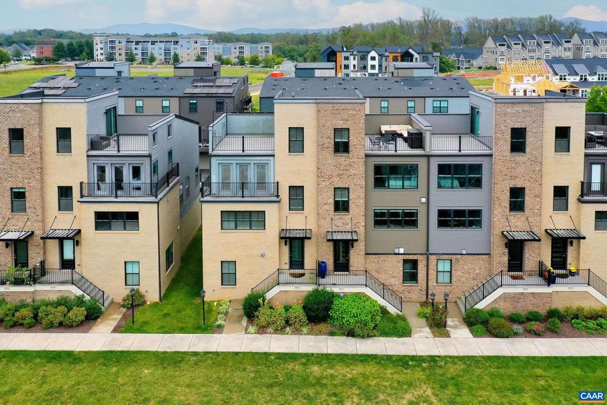 Panoramic Blue Ridge Mountain views in the heart of Old Trail Crozet. This four-level townhome on green space offers modern design and walkable access to Old Trail Town Center. Light-filled with natural hardwood floors and custom window treatments, the open-concept main level features a gourmet kitchen with espresso cabinetry, granite countertops, upgraded stainless steel appliances, and generous prep space flowing into the great room with electric fireplace and spacious dining area.  Upstairs, the primary suite includes a walk-in closet and spa-inspired bath with frameless glass shower. A second bedroom with ensuite bath provides ideal guest space. The entry level offers a flexible third bedroom, home office, or gym with full bath. The top-level loft opens to a rooftop terrace with sweeping mountain views?perfect for relaxing or entertaining. Rear deck, two-car garage, and new HVAC (2025) with warranty. Enjoy low-maintenance living in Old Trail near golf, pool, trails, downtown Crozet, and an easy drive to Charlottesville and UVA.,Granite Counter,Wood Cabinets,Fireplace in Great Room