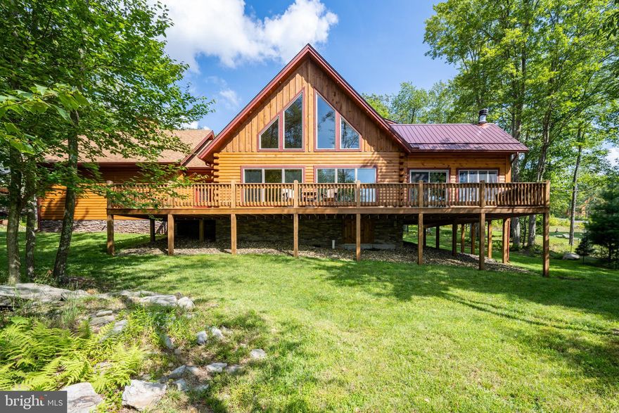 With beautiful views of the Lodestone Golf Course, this stunning log chalet—tucked along a peaceful drive in the prestigious Biltmore at Lodestone community—is a must-see! Past the entryway, step into open-concept living with oversized windows for plenty of natural lighting, accentuating the drywall/wood siding interior combination that makes the home feel both natural and modern. The exterior was professionally stained and sealed last year with fresh trim touch-ups, and a gorgeous enclosed deck was added this year by the original builder. Featuring large windows and a cozy stone fireplace, the newly enclosed space offers a seamless transition to the beautifully maintained exterior deck. Just beyond, a stone fire pit invites you to relax and take in the private and forested golf course views. The main floor offers a primary bedroom with en suite bath, along with a half bath, and a bonus pantry and laundry space for convenience. Upstairs, you’ll find three spacious bedrooms and two full bathrooms. The home is also wired and ready for a hot tub—perfect for maximizing both rental and relaxation potential. A spacious driveway and attached 2-car garage provide plenty of parking and storage. Located just minutes from Wisp Resort, ASCI, Fork Run Recreation Area, and Deep Creek Lake—this one won’t last long!