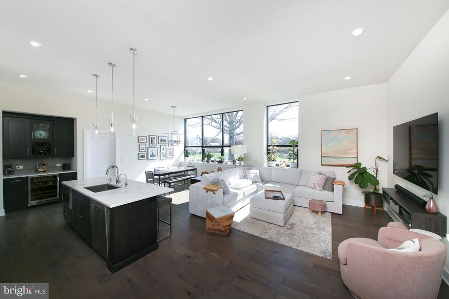 Come experience the perfect blend of luxury & character at StoneSchool! This 2BR/2.5bath condo features open concept, single-level living at its finest. As you enter the unit, you’ll walk through the spacious foyer with coat closet and relic chalkboard from the original school building. As you turn the corner into the living space, you’ll immediately be impressed by the sun-drenched living area and the wall of oversized windows. The kitchen has upgraded off-white cabinetry with many organizers, a sleek tile backsplash, and a center island with sink and seating. The stainless appliance package features a double oven and vented hood over the cooktop. The built-in wine bar with mini-fridge was a custom design. There is ample space for a generously-sized dining table and sectional couch – ideal for everyday living or entertaining friends. The powder room has a marble-top vanity with storage. Engineered hardwood floors run throughout the main living area. The primary bedroom is large, with an accent wall and ceiling fan. The walk-in closet has been outfitted with an organization system and features one of the old school classroom doors! The primary en-suite bath is nothing short of luxurious! It has upgraded tile, a shower with bench and glass doors, a double sink vanity, and custom linen tower. The 2nd bedroom – optimally located on the opposite end of the unit for privacy – is currently equipped with a Murphy bed with pull-out desk (negotiable). This room also has an en-suite bath with tub and a large vanity with storage. Even the laundry room is impressive, with its many cabinets, utility sink and granite folding counter. The owner spared no expense when designing their custom space, and a list of upgrades is available. They also installed a water softener and a reverse osmosis system at the sink. All 5-year-young mechanicals, including a tankless hot water heater. You’ll also enjoy the many amenities offered by the StoneSchool community, including an outdoor space with a fire pit and BBQ, a walking trail, a fitness center, a D.I.Y. workshop/art room, a community/party room, beautifully landscaped grounds, and a dog park.  This unit includes two assigned parking spaces—one in a covered carport and another in the general parking area. There is also a storage locker assigned to each unit, so storage is never a concern. You can walk to local stores and restaurants, or take a quick ride to the Providence Town Center or downtown Phoenixville. Stress-free living awaits!