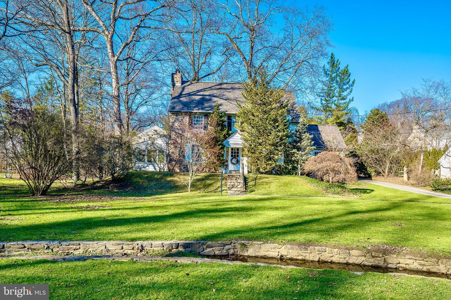 Welcome to this classic Main Line stone colonial home located on a beautiful, gently curving street in historic North Wayne.  Framed by mature trees and landscaping, this picturesque property exhibits the charm and character that defines a vintage fieldstone farmhouse with an expansive front yard crossed by a gentle stream with stone walls and bridge.    The interior of this center hall colonial offers a traditional floor plan with welcoming foyer and hallway that leads to all rooms.  Gracious LR with wood burning fireplace and built-ins leads to the office with windows on 3 sides.  To the right of the Foyer is the elegant DR with custom millwork and built-in china cabinet.  The Foyer also leads to the breakfast nook,  the kitchen, and the spacious, bright Family Room that features glass doors on two sides,  vaulted ceiling with recessed lighting, a floor to ceiling stone fireplace, opening into the kitchen, door to flagstone patio, and a half bath.  The kitchen offers white custom cabinetry, white corian counters, gas range, subzero refrigerator, and a  door to  covered back flagstone porch.  The second floor offers 3 spacious bedrooms and two baths.  The primary Bedroom has two walk-in closets, a rare treat for an older home, and a bath with tub/shower combination.  The second bedroom leads to a Bonus room that could have a variety of uses.  The third floor offers two additional bedrooms and a hall bath with claw foot bathtub.    This gem has been lovingly maintained by the same owners for 60+ years, and throughout the years some improvements and updates were made.   A whole house Generac generator was installed, two zone high velocity central air was installed, the side porch was enclosed and converted to the office, the Family Room addition was built also adding the Powder Room, and a new cedar shake roof was installed in 2016.  This is the rare opportunity to make this quintessential Pennsylvania fieldstone home your very own, and enjoy this neighborly community,  quiet streets, the active North Wayne Civic Association, and the walkability to trains and town that make Forest Road and North Wayne so special.
