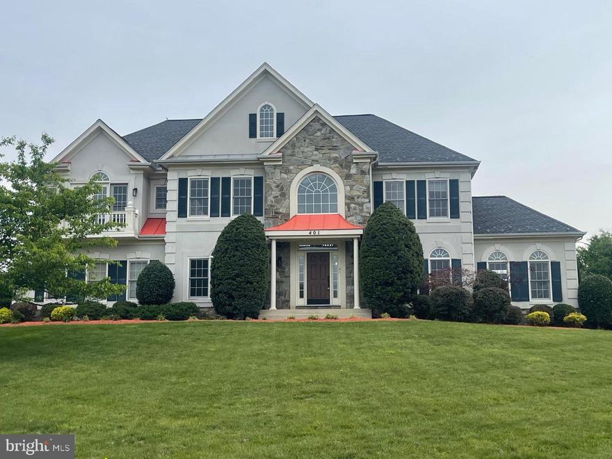 Nestled within the prestigious Hampshire Greens Golf Course community, this exceptional Colonial residence offers nearly 7,000 square feet of beautifully finished living space on a landscaped 0.72-acre corner lot. Ideally positioned with convenient access to Washington, D.C., Baltimore, and major commuter routes, the home combines timeless design with modern comfort.

Freshly painted with thoughtful updates throughout, the home welcomes you with a dramatic two-story foyer featuring soaring ceilings, crown molding, and an elegant dual staircase. The home’s open-concept design and expansive windows fill the interior with abundant natural light, creating an airy and inviting atmosphere throughout. The expansive family room is anchored by a marble corner fireplace, offering a warm and impressive gathering space.

Designed for both everyday living and entertaining, the gourmet kitchen features granite countertops, a large center island with cooktop, abundant cabinetry, a butler’s pantry, spacious breakfast area, and brand-new stainless steel appliances including a wall oven, microwave/convection oven combination, and dishwasher. The seamless flow between the kitchen and family room creates an ideal setting for entertaining and daily living alike.

The main level also includes a formal dining room, elegant living room, private office, powder room, and a stunning sunroom with cathedral type ceilings and walls of windows. Rich architectural details such as crown molding, wainscoting, and hardwood flooring add sophistication throughout the home.

Upstairs, four spacious bedrooms provide comfort and flexibility, including multiple full bath configurations and a Jack-and-Jill bath. The impressive primary suite offers a true private retreat, featuring a generous sitting area, two walk-in closets, and French doors that open to a private balcony. The spa-inspired bath includes double vanities, a soaking tub, and walk-in shower.

The fully finished walk-up lower level offers exceptional versatility with a large recreation and entertainment area, full bath, three additional oversized rooms, and extensive storage space. Ideal for a media room, fitness area, home office, hobby space, or guest accommodations, the possibilities are endless.

Step outside to enjoy a peaceful backyard setting backing to parkland and walking trails, creating a serene outdoor retreat. Community amenities include tennis courts, golf facilities, and scenic paths for recreation and relaxation. A side-entry garage and expanded parking area add everyday convenience.

Offering a rare blend of elegance, functionality, natural beauty, and refined living space, this remarkable residence presents an exceptional lifestyle opportunity in one of the area’s most sought-after communities.