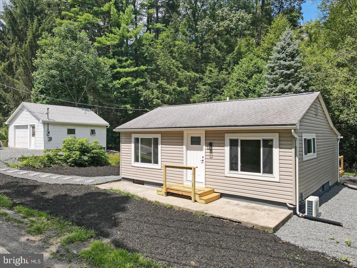 Discover this beautifully renovated 3-bedroom, 1.5-bath bungalow located just minutes from the D&L Trail, Historic Jim Thorpe, and scenic Mauch Chunk Lake. Every inch of this home has been thoughtfully updated to blend comfort with style. Step into the stunning kitchen featuring granite countertops, a stylish tile backsplash, soft-close cabinetry, and stainless steel appliances—perfect for cooking and gathering. Unwind in the spa-like main bathroom boasting an oversized soaking tub, tile surround, and elegant fluted vanity. A convenient half bath includes space-saving fixtures to maximize functionality. Enjoy year-round comfort with brand-new mini split systems for efficient heating and cooling, complemented by fresh paint, recessed lighting, and luxury vinyl plank flooring throughout that gives the home a bright and airy feel. The finished lower level offers a versatile rec room and laundry area, ideal for relaxing or entertaining. Step outside to a spacious rear deck—perfect for gatherings, grilling, or quiet evenings by the fire pit under the stars. An oversized detached garage provides ample space for vehicles, tools, or recreational gear. Backed by public utility land, this property offers added privacy and a serene natural setting. Whether you're seeking a full-time residence or a weekend escape, this move-in ready home delivers the best of both indoor comfort and outdoor adventure. Don't miss your chance to own this hidden gem!