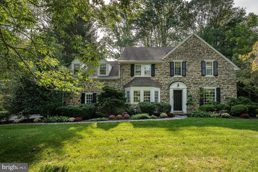 Nestled in the heart of the prestigious St. Davids section of Radnor Township, this enchanting 5-bedroom stone colonial home invites you into a world of timeless elegance and modern comfort. As you approach the property, a sense of grandeur emanates from the meticulously maintained exterior.
Stepping through the front door, you are greeted by a traditional center hall floor plan. This classic layout features a fireside formal living room with a large Bay window drenching the room with natural light and a warm and inviting ambiance.  A gracious formal dining room with a large bay window, crown molding and chair rail is ideal for hosting elegant dinner parties and celebrations. The Dining Room leads to a Butler’s  Pantry and Mud Room with a side entry.
The heart of this home lies in its expanded kitchen, designed for both functionality and aesthetics. The kitchen boasts ample counter space and features counter seating, creating a hub for casual meals and conversations or opt for the adjoining informal dining area, offering a delightful spot for morning coffee or family breakfasts.
The kitchen seamlessly flows into a vaulted ceiling family room, a space that embodies the essence of modern living. Sunlight streams in through large windows, casting a warm glow over the room's inviting furnishings. Here, you can unwind by the fireplace or simply enjoy the company of loved ones. Adjacent to the Family Room you'll discover a private office/den, an oasis of productivity and contemplation, adorned with rich wood paneling, built in bookcases and bathed in natural light. This room also has a door to the Living Room allowing for great flow or privacy when needed.
Through patio doors, the indoor and outdoor worlds harmoniously blend. Step out onto the expansive bluestone patio, professionally designed and meticulously landscaped. This outdoor sanctuary invites you to gather around a stone fire pit, perfect for roasting marshmallows or sharing stories under the starry night sky. Meander through the lush gardens, stately trees, and peaceful fish pond a true retreat for relaxation and contemplation.
On the 2nd Floor of  this remarkable home, a restful haven of sleep and relaxation awaits. Upstairs, you'll find a total of 5 bedrooms and 3 full bathrooms, all thoughtfully updated to offer both modern convenience and style. One of the ensuite bedrooms is privately located up the back staircase. 
The primary bedroom exudes an air of luxury and tranquility. As you enter, a vaulted ceiling soars overhead, creating an expansive and airy atmosphere. The focal point of the room is a raised hearth fireplace, providing warmth and ambiance on cooler evenings. His and her walk-in closets offer ample storage space, ensuring your belongings are neatly organized.
Step into the spa-like primary bathroom, with an oversized stall shower and heated towel bars. Perfect  for a refreshing start to your day. Dual vanities provide convenience, while elegant finishes and fixtures add a touch of opulence.
For those seeking a moment of respite in the fresh air, a private balcony off the primary bedroom offers picturesque views of the lovely property below. It's a perfect spot to savor a morning coffee or evening sunset.
Descending to the lower level, you'll discover an entertainment area that is sure to delight movie buffs.  Here, a fireside professional theater system awaits, ready to transport you to the world of cinema without leaving the comfort of your home. A convenient kitchenette ensures refreshments are always at hand, while a partial bathroom adds practicality to the space. A convenient cedar closet is tucked into this area.
Not to be forgotten this house is equipped with a generator in anticipation of winter blizzards and summer storms. 

An oversized lot has been recently surveyed. Subdivision may be possible but is in no way guaranteed