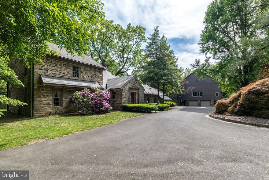 Step into a world where timeless elegance meets European charm as you enter this extraordinary 4 Bedroom, 2.5 Bath stone estate with over 4000 sq ft, built in the 1800s and thoughtfully updated over the years, evoking the enchanting feel of a cottage nestled in the English countryside, accompanied by a 4500 sq ft updated Bank Barn w/finished space & abundant storage. Beautifully situated and hidden from the road, down a long, tree-lined driveway (1 of 2 entrances), on over 3 secluded, fully fenced acres in North Wales, this property also enjoys being part of the neighborhood of Montgomery Lea, with a 2nd gated entrance within the cul-de-sac of Major Dr. This exciting home is constructed entirely of solid stone, with a slate roof & has masterfully preserved its rich historic character, w/reclaimed wood beams & hardwood floors throughout. The thick stone walls, original details, & hand-crafted finishes create a warm, storied atmosphere that is both romantic and enduring. Inside, every room tells a story, offering inviting spaces with panoramic views of the surrounding landscape. Whether enjoying a fireside evening or a sun-drenched breakfast nook, the home’s charm is palpable in every corner. The entrance foyer features a custom Butler’s Pantry and leads to an inviting Family Room w/stone floor, walk-in gas fireplace, exposed beams, & 2 sets of French doors leading to the 1st of 2 Patios overlooking luscious rear grounds. A 2nd set of French doors opens to the extremely spacious Living Room w/exposed beams, wide plank hardwood floors, 2nd walk-in gas fireplace & included hutches.  A stunning stone wall w/arched opening leads from the Family Room to the lovely Dining Room with a gas stove sitting within a stone niche, wood ceiling w/exposed beams, & included custom table & chairs. The enchanting, updated country kitchen features a tiled floor, peninsula w/maple counter, cabinets constructed from reclaimed barn wood, newer double Viking stainless wall ovens, tiled backsplash, stainless dishwasher, electric stove w/griddle, & walk-in pantry closet. A full wall of windows adds warmth & a panoramic view of the rear grounds. Relax or entertain in the adjacent sun room w/walls of windows, a vaulted ceiling w/glass panels & a built-in bar w/gas stove & quartz counter. A French door from this room leads to the 2nd exterior Patio. The 2nd floor features a spacious Master Ste with 4th fireplace in the Bedroom, Dressing Room w/new carpet and multiple walk-in closets, and totally updated Full Bath w/vanity w/marble counter & stall shower w/frameless glass door. 2 Additional Bedrooms plus a renovated Hall bath & the Laundry Rm w/included washer & dryer complete the 2nd floor. The 4th Bedroom with new carpet is located on the 3rd Floor. An unfinished basement includes Central Vac, a water softener, gas furnace, Bilco doors, & radon remediation system, plus there is a hookup available to connect to public water. Enjoy the outdoors on the 2 inviting flagstone patios overlooking the lushly landscaped grounds featuring specimen trees & shrubs, a wishing well & delightful tree house. Adding even more appeal is a stunning 4,590 sq.ft. bank barn, thoughtfully restored to complement the main residence, including brand new siding. Within the barn, you’ll find 1360 sq ft of finished living space complete with a large gym w/included universal & weights. This spectacular space is ideal for guests, hobbies, creative space, or even a private office & includes 3 floors of unfinished space w/unlimited potential including workshops, storage & more. The lower level offers a 4-Car Garage, & a covered stone portico overlooking the manicured grounds. The panoramic views of nature and the property’s seclusion offer the tranquility of a countryside retreat and yet the benefits of being a part of a neighborhood. With its storybook architecture, rich materials, & lush surroundings, this one-of-a kind property is a true blend of history, luxury, and charm.
