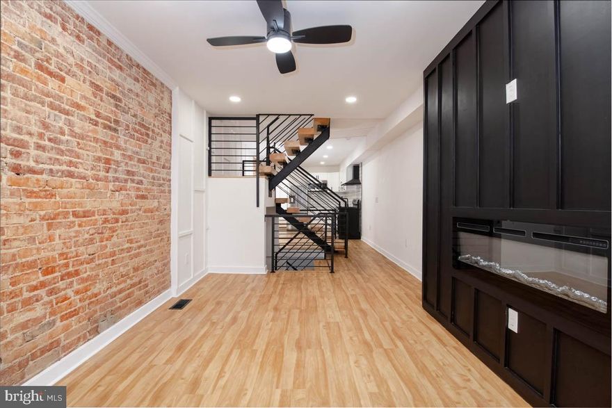 Step into this stunning home, featuring brand new luxury vinyl plank (LVP) flooring that beautifully complements the modern aesthetic throughout. The heart of the home is a fully updated kitchen, boasting sleek stainless steel appliances, a stylish stove with a built in hood, and elegant quartz countertops that provide both functionality and flair. The custom rails add a touch of sophistication, giving a high-end feel to the space. Cozy up in the living area next to the accent wall with a built-in fireplace, creating a perfect ambiance for relaxation and entertaining. Head down to the finished basement, offering additional living space perfect for a media room, home gym, or play area. Outside, enjoy the convenience of a dedicated parking pad, making coming and going a breeze. This home seamlessly blends modern design with comfort, making it the perfect place to create lasting memories.