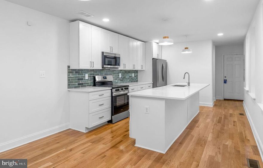 Welcome to 51 S. Fulton Street, where historic Baltimore architecture meets refined modern living. This fully reimagined rowhome has been transformed with upscale finishes, elevated design choices, and a level of craftsmanship that sets it apart in a rapidly revitalizing neighborhood.
Step inside to discover an inviting open layout with designer lighting, wide-plank flooring, and a sophisticated flow ideal for both everyday living and stylish entertaining. The gourmet kitchen serves as the home’s centerpiece, showcasing custom soft-close cabinetry, premium quartz surfaces, and a suite of brand-new stainless steel appliances that blend performance with elegance.
Upstairs, two beautifully appointed bedrooms and two spa-inspired full baths offer boutique‑hotel comfort, complete with modern tilework, sleek fixtures, and thoughtful details throughout. A convenient half bath on the main level adds to the home’s effortless livability.

Every major system has been upgraded — including the roof, HVAC, water heater, and electrical — ensuring long-term reliability and peace of mind. The property is also grant-eligible and qualifies for several Baltimore City homeownership incentives, including down payment and closing cost assistance for eligible first-time buyers.

Move-in ready and meticulously finished, 51 S. Fulton Street delivers a luxurious living experience wrapped in the charm of a classic Baltimore rowhome — the perfect blend of character, comfort, and modern sophistication.