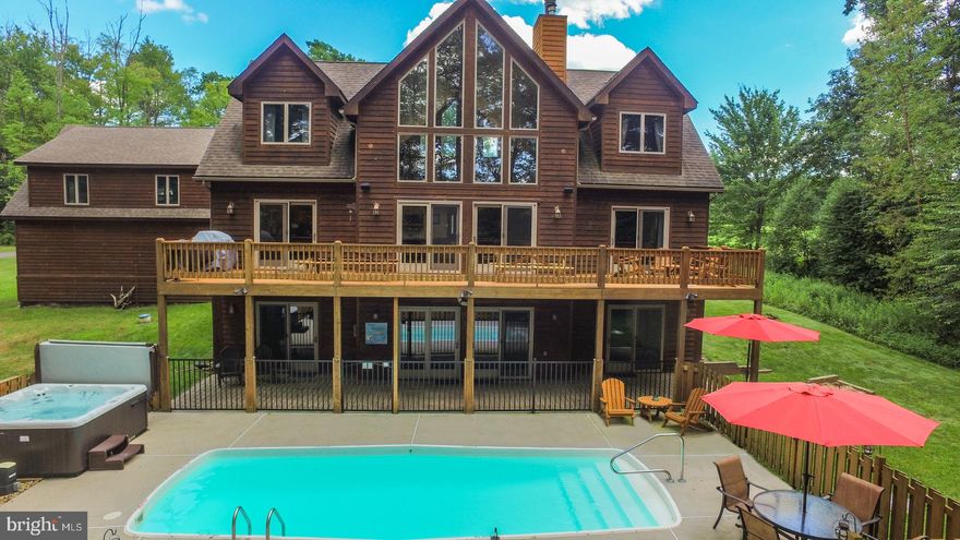 If you are looking for a home that checks off all the boxes, this is it! "Midnight Dip" is an established vacation rental and one of the "most loved" on Airbnb . Offering six bedrooms, an open floorplan, impressive floor-to-ceiling stone fireplace, new landscaping/hardscape, new granite in the kitchen and new LVT flooring on the main and lower-level living areas. The abundance of windows brings in a lot of natural light, along with some views of Deep Creek Lake. The detached 2-car garage provides plenty of storage and a bonus room above that could be finished for additional entertainment space. Offering 150' of lakefront for your enjoyment with a maintained path leading right to the lake access and kayak racks. Not to mention a great deck, gorgeous outdoor pool, hot tub, horseshoe pit and fire pit.  This home is an ideal place to enjoy in every season. Located in the beautiful Waterfront Greens community that offers many amenities including a par-3 9-hole golf course, mini golf, and a tennis court.