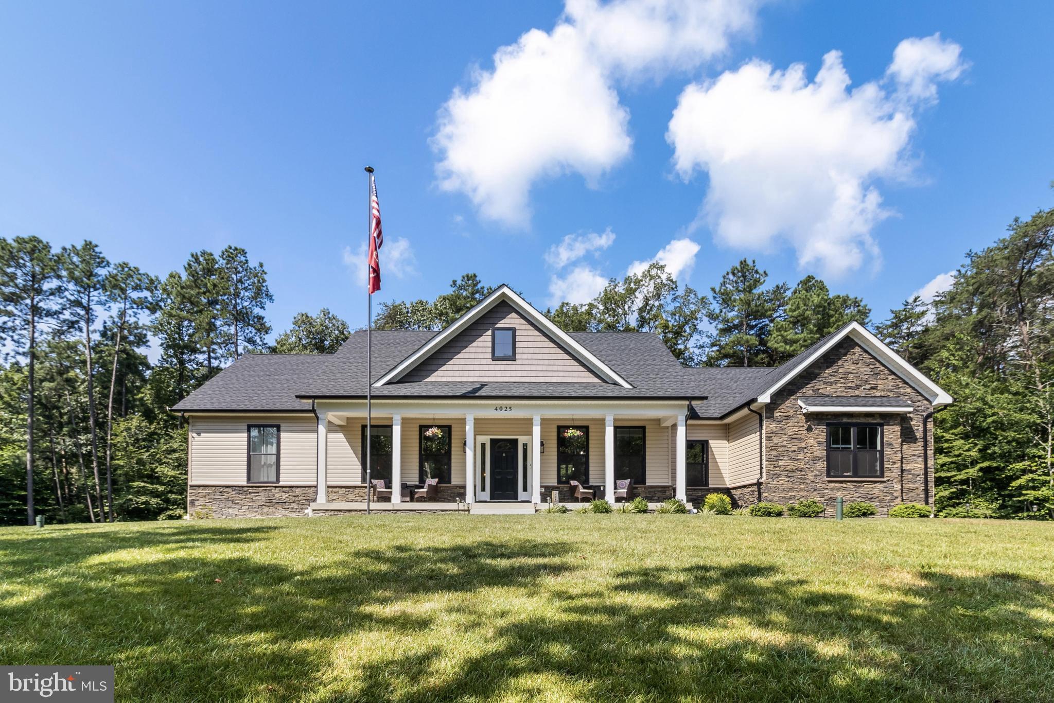 Welcome to this custom built, 4,600 square feet (2,300 finished and 2,300 unfinished) custom rambler situated on 3 acres at the end of a cul-de-sac in Charles County. Only 2 years young! Designed with an open floor plan, this home is a true entertainer’s dream. From the moment you arrive, the home makes a striking first impression with its stone façade, stately front porch, manicured landscaping and side-entry 3-car garage. The interior offers a seamless open-concept layout with vaulted ceilings, luxury vinyl plank flooring and a cozy fireplace anchoring the spacious great room. Designed with an open floor plan, this home is a true entertainer’s dream. The gourmet kitchen is a chef’s dream, featuring stainless steel appliances, granite countertops, 42-inch cabinetry, a walk-in pantry, built-in microwave and an oversized island perfect with seating for entertaining. Step outside to your expansive composite deck—ideal for summer barbecues and quiet mornings with coffee. The large backyard is surrounded by mature trees, offering privacy and space to explore nature or relax. The primary suite is thoughtfully positioned in its own wing and boasts a spa-like ensuite with a custom oversized tiled shower, separate water closet, dual vanities and a massive walk-in closet. Two additional bedrooms are located on the opposite side of the home and share a full hallway bath with upscale finishes. A dedicated home office (or potential fourth bedroom) adds flexibility to the floorplan. Other highlights include a spacious laundry room with sink, a mudroom/drop zone off the garage entrance at the entrance of the 3 car garage. The full unfinished basement with high ceilings, full 3-piece bathroom rough-in, includes a walk-out exit and offers incredible potential for future expansion, whether you envision a home theater, gym or guest suite. Enjoy peace, privacy and the convenience of modern living, all just minutes from local amenities. Ideally situated near Costco, Target, Starbucks, National Harbor, MGM, Tanger Outlets, MedStar Hospital, and a wide variety of restaurants, parks, and trails, including Cosca Regional Park and the Southern Area Aquatics & Recreation Complex. Commuters will love the easy access to Joint Base Andrews, the Pentagon, Bolling, MD-5, I-495, Washington, DC, Virginia, and public transit. Enjoy the perfect blend of convenience and quiet estate living.