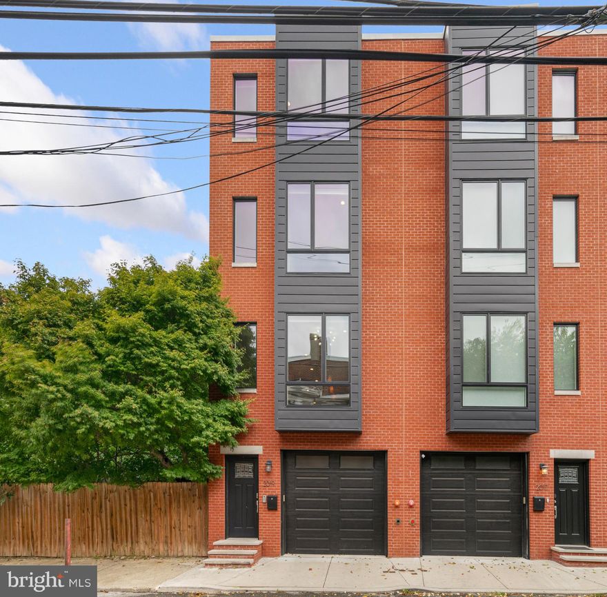 Tucked away on a quiet block just off Fairmount Ave, you'll find 2019 North St. This modern 2,700+/- sqft luxury home offers 4 bedrooms, 3.5 baths, hardwood floors throughout, multiple outdoor spaces, dual-zone HVAC, and a huge 2-car garage that can double as a gym. Out front, there's a handsome red brick facade befitting the established homes in the neighborhood. Inside, you're welcomed by a foyer with access to the expansive garage. Currently set up for 1-car parking with a fitness area, this flex space could be used for 2 cars or storage. There's also a full bathroom and a rear door leading to a private patio, ideal for grilling. Up on the home's main level, beautiful hardwood floors stretch across the open layout. A stone fireplace and built-ins anchor the living room while sliding doors open to a rear terrace that can be transformed into a garden oasis for relaxing or al-fresco dining. At the center is a gleaming gourmet kitchen fitted with custom wood cabinetry, high-end JennAir and BlueStar appliances (fridge, range and range hood), including a wine fridge, a pot filler over the 6-burner range, reverse osmosis water system under the sink and a waterfall island with seating. The dining area features extended cabinetry, a chandelier, and floor-to-ceiling windows. The home's third level has a spacious bedroom suite at the rear with an attached full bathroom and double closets. A laundry room and second bathroom sit off the hall, with another bright bedroom at the front. The fourth level of the home hosts the primary suite. It's comprised of a large bedroom filled with natural light from tall windows, a walk-in closet with room to share, a sleek full bathroom adorned with a dual vanity and double rainfall, plus an additional bedroom perfect for an office or nursery. Topping off the home is a roof deck that's sure to be your go-to spot for hanging out with friends and family while enjoying skyline views. In addition to everything inside, this fantastic location in the heart of Fairmount earns a Walk Score of 94! Around the corner, Fairmount Ave is lined with top-rated restaurants and friendly shops. Whole Foods, Wine & Spirits, and Target are nearby, plus idyllic parks and iconic landmarks like The Philadelphia Museum of Art, Kelly Drive, and Eastern State Penitentiary are close. There's also easy access to the Community College of Philadelphia, I-676, I-76, Spring Garden St, Broad St, and public transit. Schedule your in-person or virtual tour today! Some photos have been virtually staged.