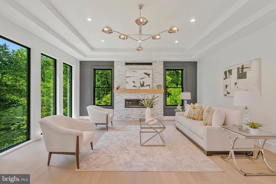 Modern Elegance Meets Resort-Style Living in the Heart of McLean
Nestled on a rare, flat 31,533 sq ft lot in a quiet McLean enclave, this architecturally striking residence blends modern design with resort-style amenities. The expansive, level grounds are ideal for a future pool or a game of soccer, easily watched from the comfort of the screened porch—perfect for family living and entertaining.
Backing to a tranquil creek and lush wooded views, the property offers exceptional privacy and a serene natural setting. A sleek stucco façade, expansive glass windows and doors, and a spacious three-car garage create impressive curb appeal.
Inside, soaring 10-foot ceilings on all levels enhance the home’s open, airy atmosphere. Luxurious finishes include 10-inch wide pre finished oak hardwood floors, solid 8-foot modern doors, and exotic designer lighting throughout. The open-concept layout flows seamlessly into a dramatic family room featuring a floor-to-ceiling linear gas fireplace, and a large screened porch with metal-framed screens and a gas fireplace—ideal for year-round entertaining.
The primary suite is a private sanctuary, complete with its own gas fireplace, a Juliet balcony, and a secluded terrace overlooking the scenic backyard. Whether you're sipping morning tea or enjoying a quiet evening read, the peaceful natural surroundings are always in view. The ensuite bathroom is a modern masterpiece, featuring heated floors, elegant finishes, and spa-like comfort.
Each additional bedroom on the upper level is ensuite, offering exceptional privacy and comfort for family or guests. Every room includes custom walk-in closets, marble-topped vanities, and beautifully tiled bathrooms that reflect timeless elegance and quality craftsmanship.
The fully finished, walk-out lower level continues the home’s luxurious feel with high ceilings, large windows, and abundant natural light. At the center is an expansive recreation room with a custom wet bar, rich wood paneling, ambient lighting, and a cozy stone fireplace. A state-of-the-art media room with tiered seating provides a true cinematic experience, while a dedicated exercise room with access to a full bath offers flexibility for workouts or guest accommodations.
Located just minutes from downtown McLean, top-rated schools, premier shopping, dining, and major commuter routes, this residence offers a rare combination of luxury, livability, and convenience.