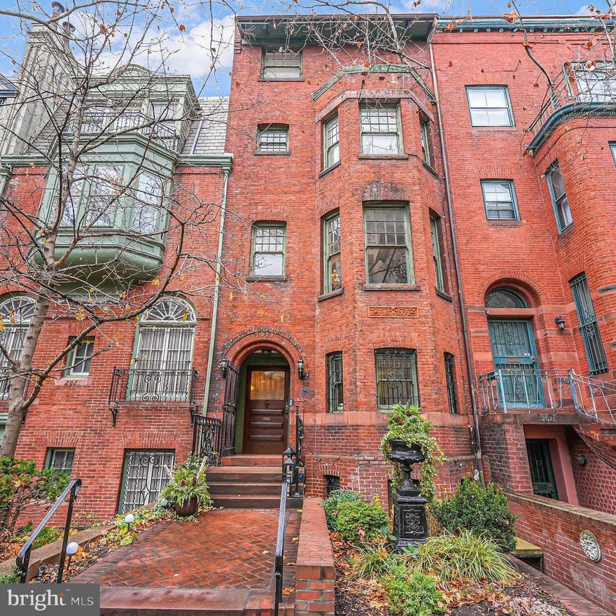 Welcome home to Dupont West 1890's six bedroom, three and a half baths historic home, featuring spectacular original details throughout an estimated 5700 square feet of living space.  Entering through the restored front door on the main level, guests are immediately struck by the sprawling 2023 restored hardwoods, paneling, grand center staircase with skylight flooding all 4 above ground levels with natural light.  The main level encompasses a formal sitting room, cozy family room, powder room and exit to the fenced four space parking area.  One level up is the formal dining room, kitchen, and living room.  The primary bedroom is located on the next level complete with laundry, walk-in closet, full bathroom, and an additional bedroom.  The fourth upper level has a full bath, study, three bedrooms and access to the fifth level floored and unfinished attic.  The large lower level offers versatility with a full kitchen, living/dining room, bedroom, full bath, laundry and separate front and rear entrances, as well as inside staircase entrance ideal for friends and family gatherings or an au pair suite.  This home offers a tremendous amount of 135 year old architectural features designed by famed Architect William J Marsh: 11  fireplaces, many with original tiles and mantels, 10 ft. plus ceilings,  original pocket doors, grand staircase, and the list goes on. 
 Dupont Circle is your commuter, foodie and shopper's  dream location with a historical soul.