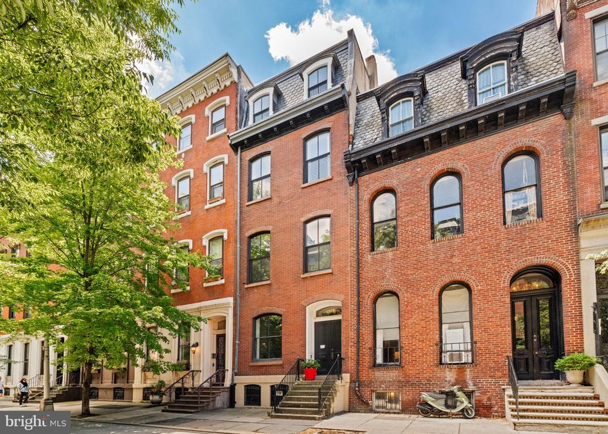 Moving along the 2000 block of Spruce St, you’ll be amazed at the stature and scale of all the old homes lining the way. Many if not most are behemoths, stretching nearly 120’ in length, covering their entire plots with room after room of Victorian scaled spaces.  But not this pearl at number 2026.  This building’s footprint occupies a little more than half the lot, leaving space for an amazing south facing garden, filled with mature plantings and areas carved out for relaxing and entertaining.  And just beyond the garden, behind the cedar fence, is enough paved space for two normal sized cars. It doesn’t seem possible that a setup like this can still exist in Rittenhouse Square, in the heart of Philadelphia.  And yet here it is, awaiting the next stewards to move this spirited home along its wonderful journey, just as the creative current owners have for the last 20+ years

The 1st level sits well above the street.  All of the needed spaces are here; a double doored entry foyer, a sitting room, a newer powder room and kitchen, and the most comfortable dining room in Center City, anchored by a fireplace and poised over a butterfly filled garden of healthy plants in various states of bloom.

The building plan is a “dumb-bell” in form, the center being dominated by service rooms such as baths and closets, and an oval shaped stairwell that climbs 4 stories up to the top floor studio and bedrooms. The formula is similar on each floor; at the front, a large north facing room with giant windows and plentiful walls for art and objects.  To the south, at the rear, one or two bedrooms, also with enormous windows, look out over the garden below.  Out of sight and above the curving stairwell is the original skylight, covered by the previous owner in past renovations.  There it sits, waiting for its day in the sun.

From this location, you’re two blocks from Rittenhouse Square and five or six blocks from Fitler Square. And the house is a short distance from too many cultural institutions and eateries to name.  If you do decide to stop by for a visit with your agent, swing by CORK The Wine Shop at COOK.  Grab a cold, crisp bottle of effervescent Vinho Verde and take a few minutes to sit and enjoy this garden oasis, and ponder what might come next.