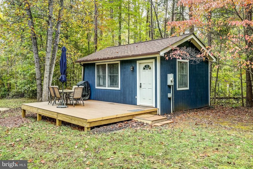 Imagine escaping reality to your very own private, adorable, and furnished lake house at Lake Anna, Virginia.   Surrounded by lush green trees on a one acre lot, this well-maintained water access cottage is just a short walk from the lake, where you'll find your own deeded boat slip.   Ideal for weekend getaways to enjoy boating, fishing, or just a few days of quiet peaceful solitude, this cozy cabin on the private side of Lake Anna has it all.   Spread out inside in the spacious living room / bedroom combo, where you'll find quality LVP flooring throughout, a full bathroom with shower and plenty of storage space, and a convenient kitchen with refrigerator, microwave, and plenty of cabinet storage space.  A mini-split unit provides superior air temperature control, both heat and cooling, throughout the entire home.  Unwind outside on the large front deck, constructed with maintenance free composite decking, or at the fire pit in the large front yard.  Furniture, furnishings, and decor can convey on purchase.  Home has outdoor 50amp outlet for RV hookup or type 2 electric car charger. Great location: less than 10 minutes to restaurants, groceries, The Lake Anna Taphouse, vet clinic, ABC, and more!  INVESTORS: this home would make a great short term rental, given the quality of the home, the short distance to the water, and the dedicated boat slip.  Lake Anna was recently ranked the top short term rental destination in the country.