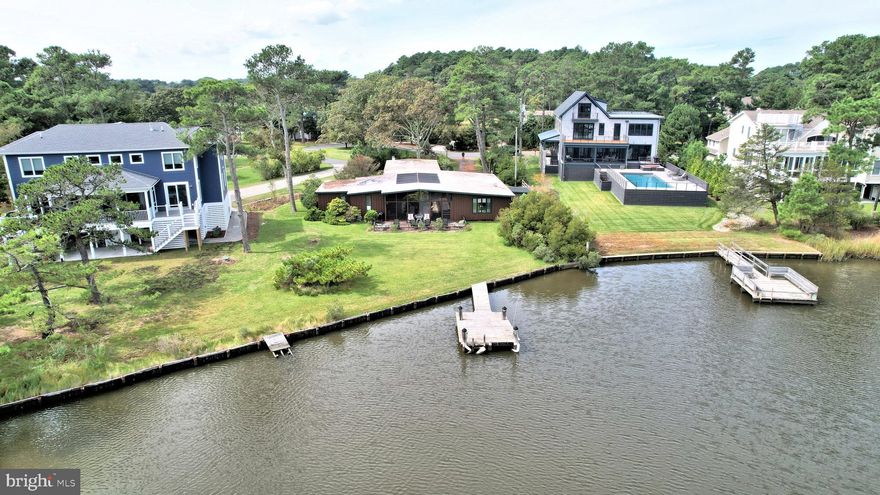 Welcome to 37 Holly Road! 
Located on a quiet cud-de-sec in private North Shores, this property has not been on the market since 1969 and is a rare opportunity to acquire a waterfront property on North Shore’s Yacht Basin – either for the existing classic North Shores atrium-style home or as a redevelopment site.  

The location is ideal – close to the North Shores’ private beach, community pool, tennis and pickleball courts, bike trails and other amenities, and also offers a large yard behind an existing bulkhead and a private dock.   With minimal boat traffic in the Yacht Basin, the dock is a great place to soak up the sun, go crabbing or fishing, and is the ideal location for launching kayaks, canoes, paddle boards and other water sports.  Or keep a powerboat at the dock and explore the canal, Lewes, Rehoboth or Delaware Bays, or the nearby marshes at Gordon’s Pond.  

This classic waterfront atrium house features a main section with an open kitchen/living and dining area, with full height glass walls and doors that open to a large, screened atrium.  The main section also includes an en suite bedroom and bath.  On the other side of the atrium are 3 additional bedrooms, 2 half baths plus a separate room with shower and tub. The atrium provides great natural daylight for the living areas and bedrooms, and offers a wonderful indoor-outdoor space, perfect for relaxing, gatherings and enjoying the water view. There is also a separate cottage with central air conditioning and heat, bathroom, fireplace and enclosed porch. With plenty of off street parking, a relaxing sun deck and a refreshing outdoor shower, the home is the perfect vacation spot!  This home is being offered fully furnished, if desired.